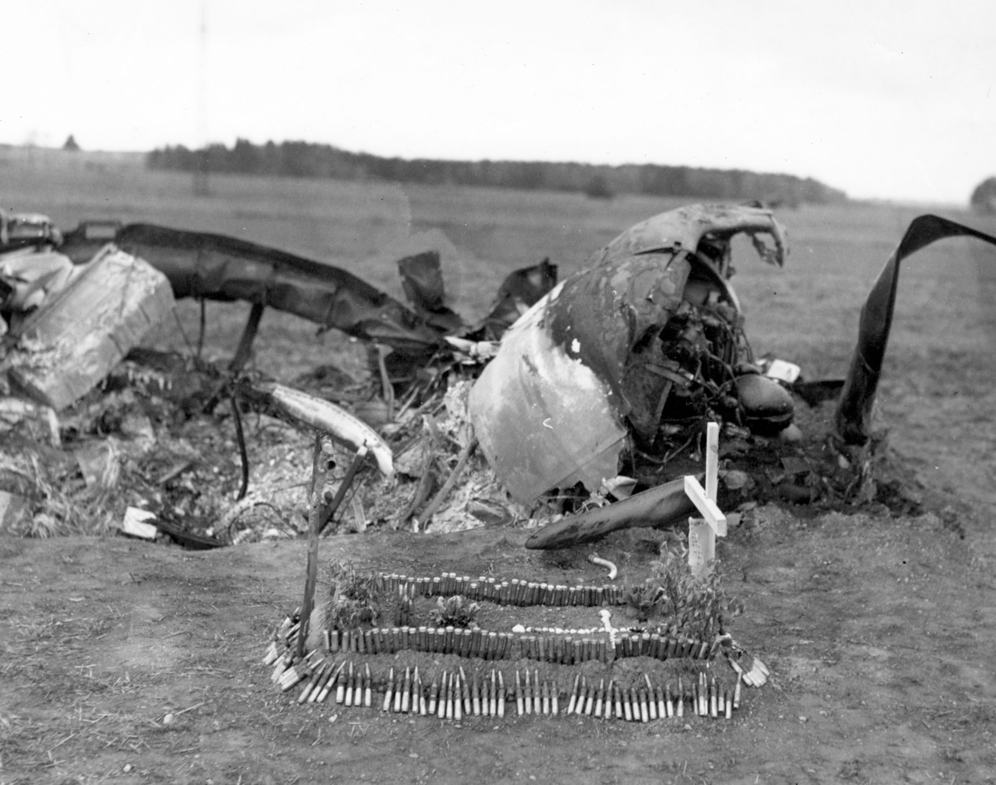 When a squadron of P-47 Thunderbolts attacked a gunpowder storage depot, the ensuing explosion destroyed one of their aircraft. The grave for the pilot was made by a refugee French couple, with .50-cal. ammunition for a border. (U.S. Air Force photo)