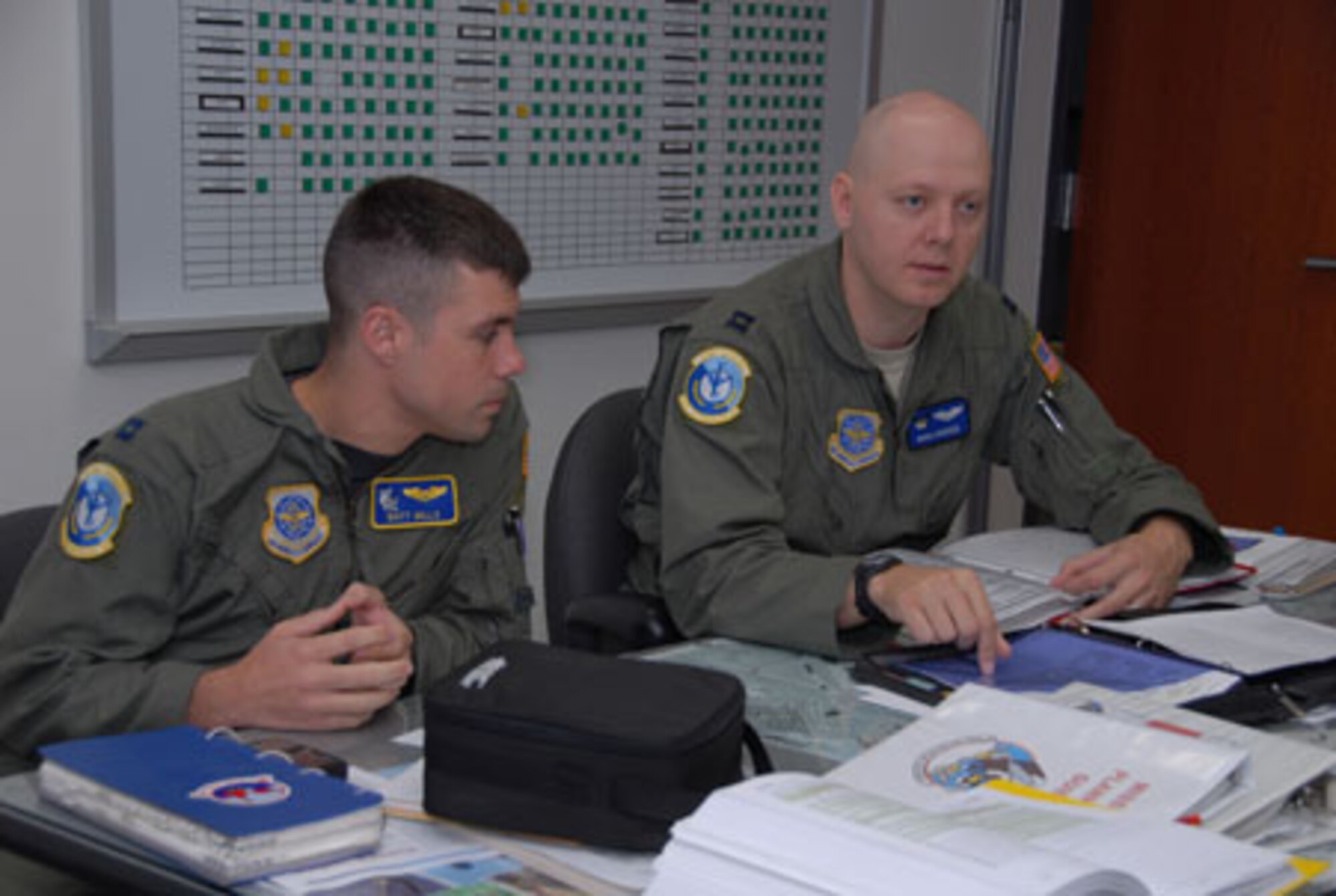 SCOTT AIR FORCE BASE, Ill. -- Capt. Matt Mills, (left), and Capt. Doug Booser, both KC-135(R) Stratotankerpilots with the 906th Air Refueling Squadron, take part in a pre-flight crewbriefing prior to an aerial refueling mission for the 906th ARS. Their flight on Sept. 9 marked the first time that an all Active Duty crew flew planes owned and maintained by the 126th Air Refueling Wing, Illinois Air National Guard, Scott Air Force Base, Ill. (U.S. Air Force photo by Master Sgt. Ken Stephens)
