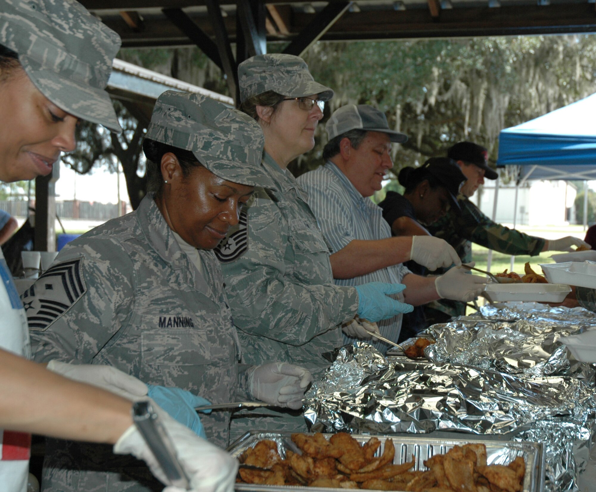 Chief Master Sergeant Gigi Manning and Chief Master Sergeant Georgia Fallow, both members of the 315th Aircraft Maintenance Squadron, serve fish and hush puppies at the semi-annual Chief’s Fish Fry here today.  The Charleston Chief's Group has had a cookout fundraiser twice a year for the last 24-years. Money raised from the event will be distributed back to Team Charleston's Airmen through programs that the Chief's Group supports. (U.S. Air Force photo/Tanya Koch)