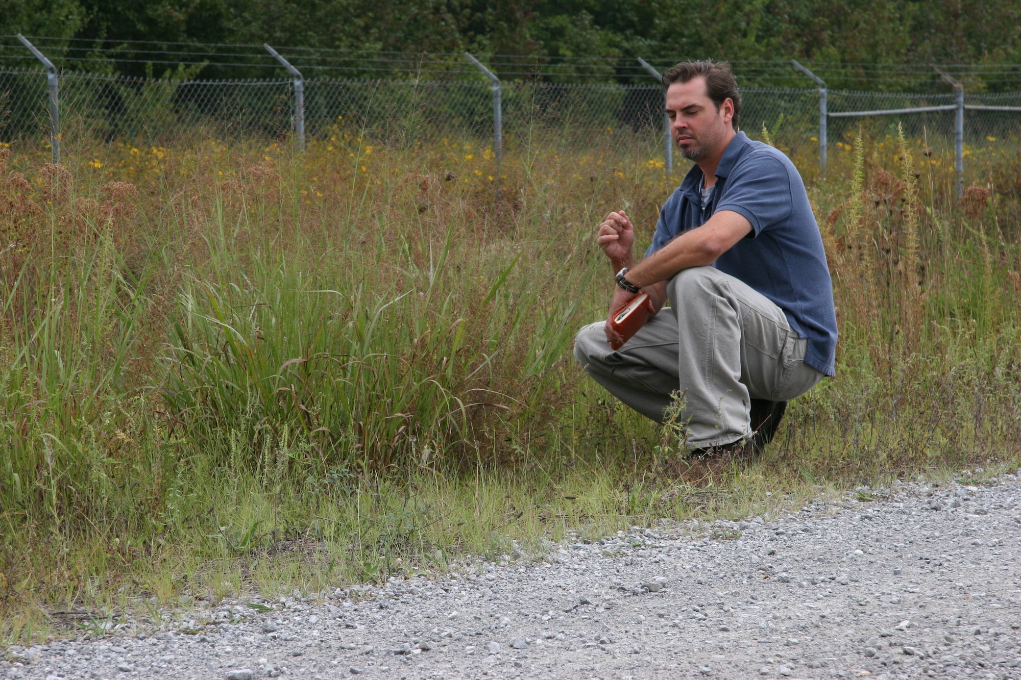 Kevin Willis, Arnold Engineering Development Center botanist, checks the effects of the prescribed herbicide treatment on weeds and native species along the Arnold Airfield perimeter road. (Photo provided)