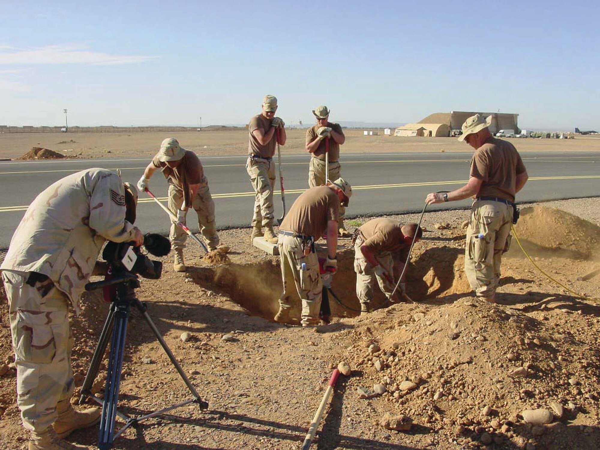 Air National Guard and 38th CEG members excavate adjacent to a hand hole, in order to extend a conduit-duct run during Operation Iraqi Freedom. (Courtesy photo) 