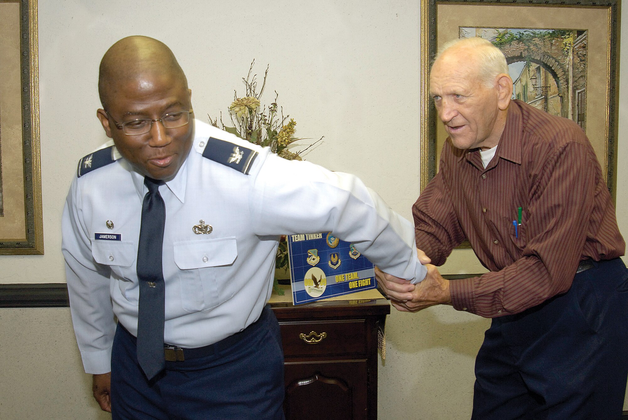 Famed wrestler, boxer and Oklahoma native Danny Hodge gently demonstrates a winning move on Col. Allen Jamerson,72nd Air Base Wing and Tinker installation commander, during the champ’s visit to base Sept. 29.  Colonel Jamerson, a huge wrestling fan, gave Mr. Hodge, his wife and mutual friends Michael and Pam Kloiber, a tour of base and a chance to meet Airmen during a luncheon. Mr. Kloiber, Tinker Federal Credit Union president and CEO, learned of Colonel Jamerson’s passion for all things wrestling and told him of their friendship with the famous wrestler and boxer. Mr. Hodge earned an Olympic Silver Medal in 1956, was the 1958 Golden Gloves champion, the 1968 TWWA Heavyweight winner and was the only amateur wrestler ever featured on the cover of Sports Illustrated.  (Air Force photo by Margo Wright)
