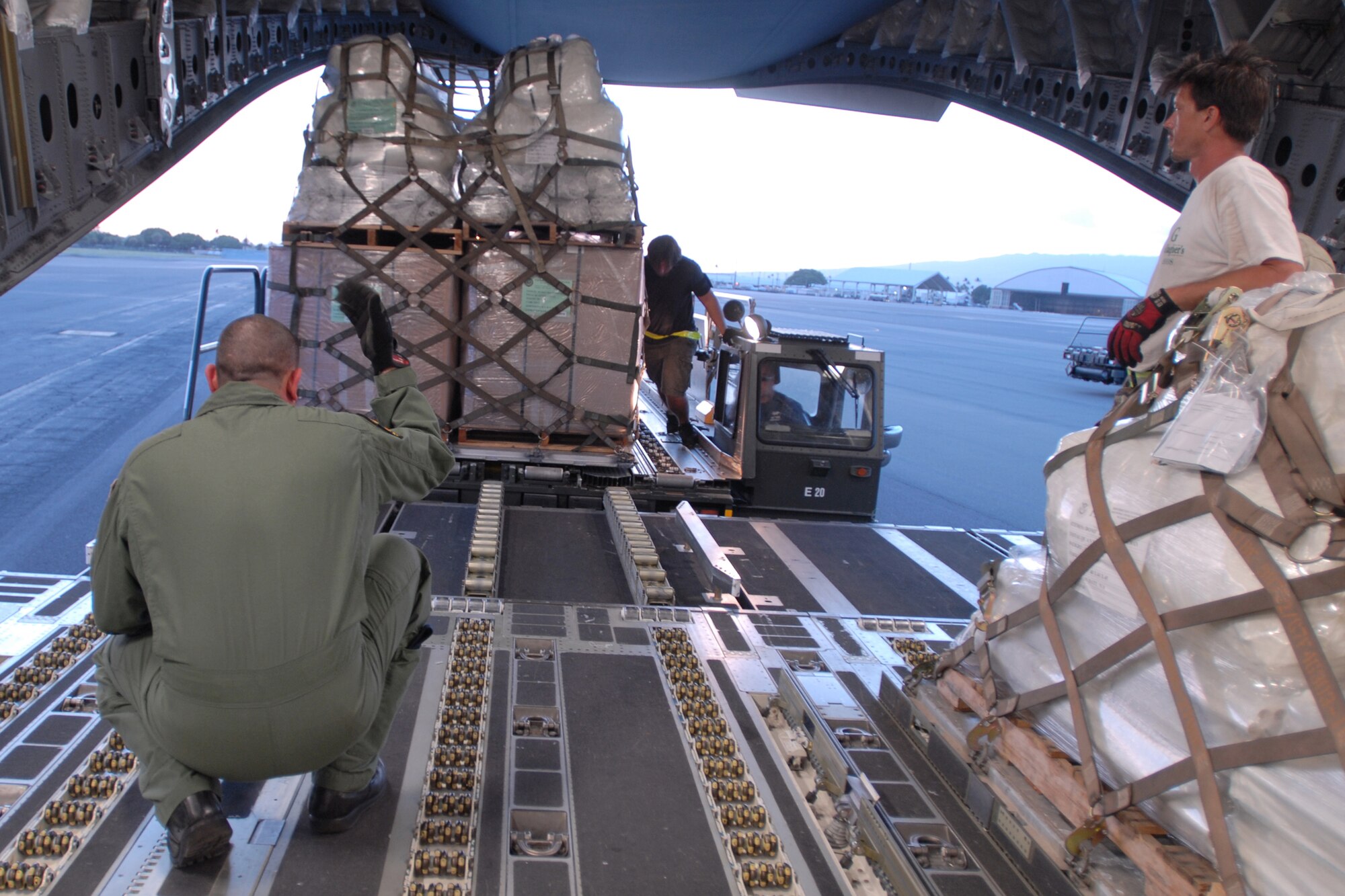 Tech. Sgt. Kimo McKee directs the loading of humanitarian aid supplies from the Federal Emergency Management Agency by Hawaii Air National Guard, Hawaii National Guard and Hickam Air Force Base active-duty Airmen into a C-17 Globemaster III bound for American Samoa to assist in the relief efforts under way Sept. 30, 2009, at Hickam AFB, Hawaii. The efforts are in the wake of tsunamis triggered by an undersea earthquake Sept. 29 that has left more than 140 people dead in the South Pacific region. More than 90 Airmen and Soldiers deployed from Hawaii for the humanitarian mission. Sergeant McKee is a Hawaii Air National Guard loadmaster. (U.S. Air Force photo/Staff Sgt. Mike Meares) 
