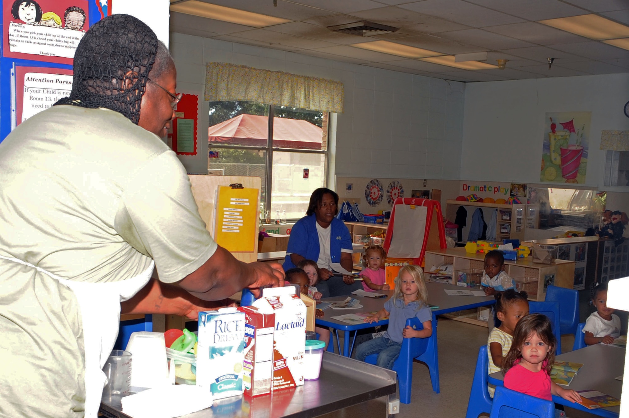 Joyce Milton, the chef at the Barksdale Child Development Center, serves children graham crackers and milk during snack time. Ms. Milton has been the chef at the CDC for more than 25 years. (U.S. photo/ Airman 1st Class Brittany Y. Bateman)