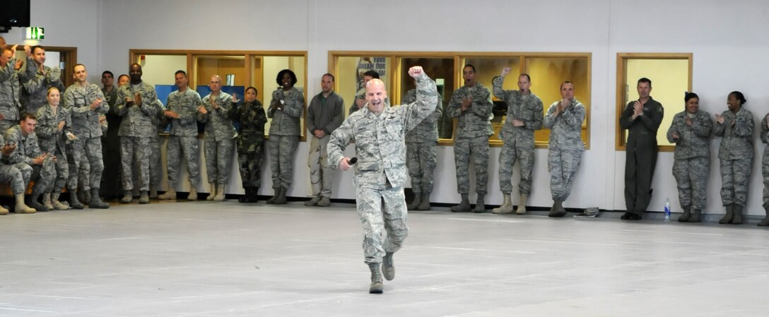 RAF MILDENHALL, England -- Col. Chad Manske, 100th Air Refueling Wing commander, makes a grand entry to the pre-Operational Readiness Inspection pep rally at the Hardstand Fitness Center Oct. 2.  The pep rally was held to inspire Airmen to perform to the best of their abilities during the two-week inspection, which begins Oct. 5.  (U.S. Air Force photo/Staff Sgt. Austin M. May)