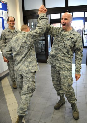 RAF MILDENHALL, England -- Col. Chad Manske, 100th Air Refueling Wing commander, gives an enthusiastic high five and cheer to a passing Airman after his pre-Operational Readiness Inspection pep rally Oct. 2.  The two-week inspection begins Oct. 5 and will test the wing's ability to deploy and fight a simulated war.  (U.S. Air Force photo/Staff Sgt. Austin M. May)