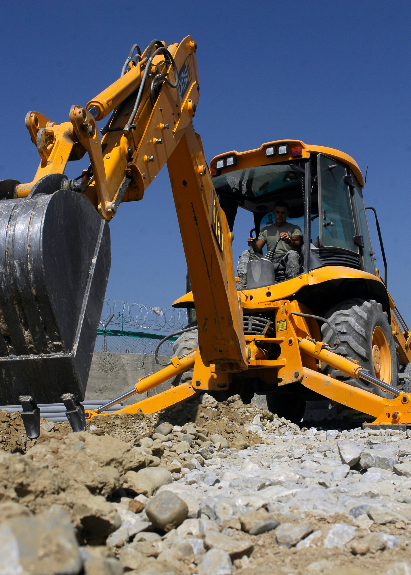BAGRAM AIRFIELD, Afghanistan -- Staff Sgt. Denver Robison, a pavement equipment craftsman from the 455th Expeditionary Civil Engineering Squadron, breaks through rocks and dirt while digging here, Oct. 2, 2009.  The trench is being excavated so that pipes can be laid giving the communications squadron an easy way to lay wiring provideing internet and phone services to new facilities.  Sergeant Robison is deployed from the Arkansas Air National Guard's 188th Fighter Wing CES, and hails from Fayetteville, Ark.  (U.S. Air Force photo/Senior Airman Felicia Juenke)