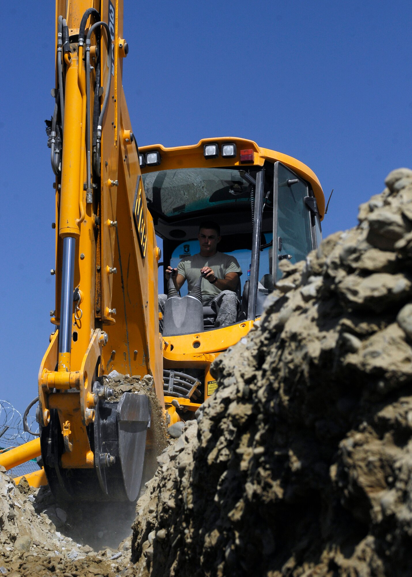 BAGRAM AIRFIELD, Afghanistan -- Staff Sgt. Denver Robison, a pavement equipment craftsman from the 455th Expeditionary Civil Engineering Squadron, breaks through rocks and dirt while digging here, Oct. 2, 2009.  The trench is being excavated so that pipes can be laid in order to give the communications squadron an easy way to route the wiring providing internet and phone services to new facilities.  Sergeant Robison is deployed from the Arkansas Air National Guard's 188th Fighter Wings CES, and hails from Fayetteville, Ark.  (U.S. Air Force photo/Senior Airman Felicia Juenke)