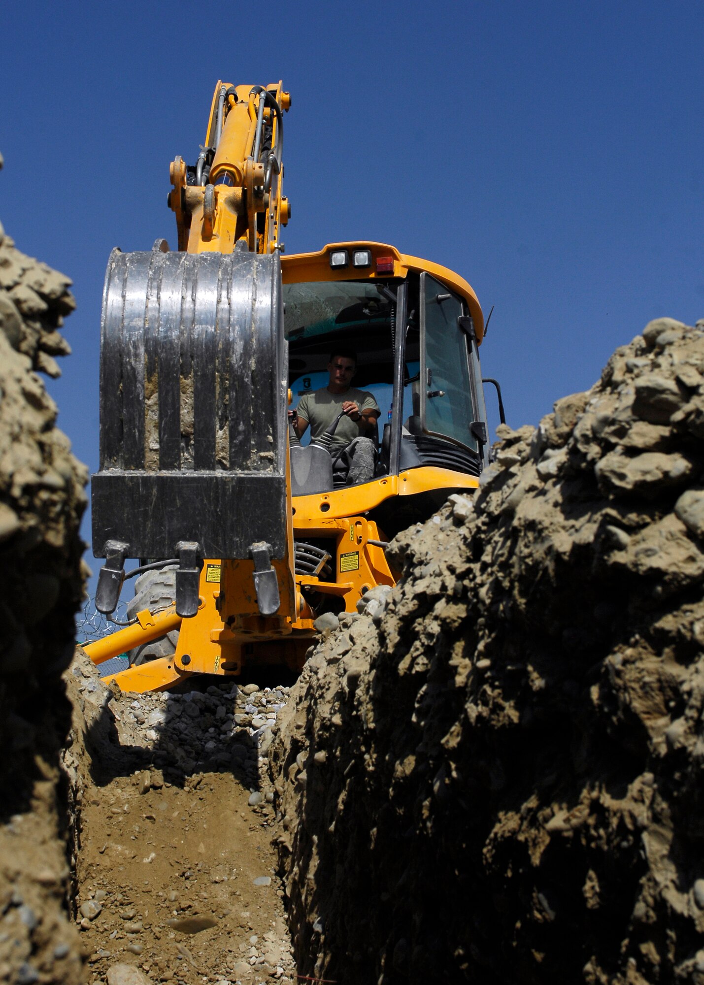 BAGRAM AIRFIELD, Afghanistan -- Staff Sgt. Denver Robison, a pavement equipment craftsman from the 455th Expeditionary Civil Engineering Squadron, digs a trench near the flightline to lay pipe here, Oct. 2, 2009.  The pipe is used as an easy way for the communications squadron to route the wiring that provides internet and phone services to new facilities.  Sergeant Robison is deployed from the Arkansas Air National Guard's 188th Fighter Wing CES, and hails from Fayetteville, Ark.  (U.S. Air Force photo/Senior Airman Felicia Juenke)