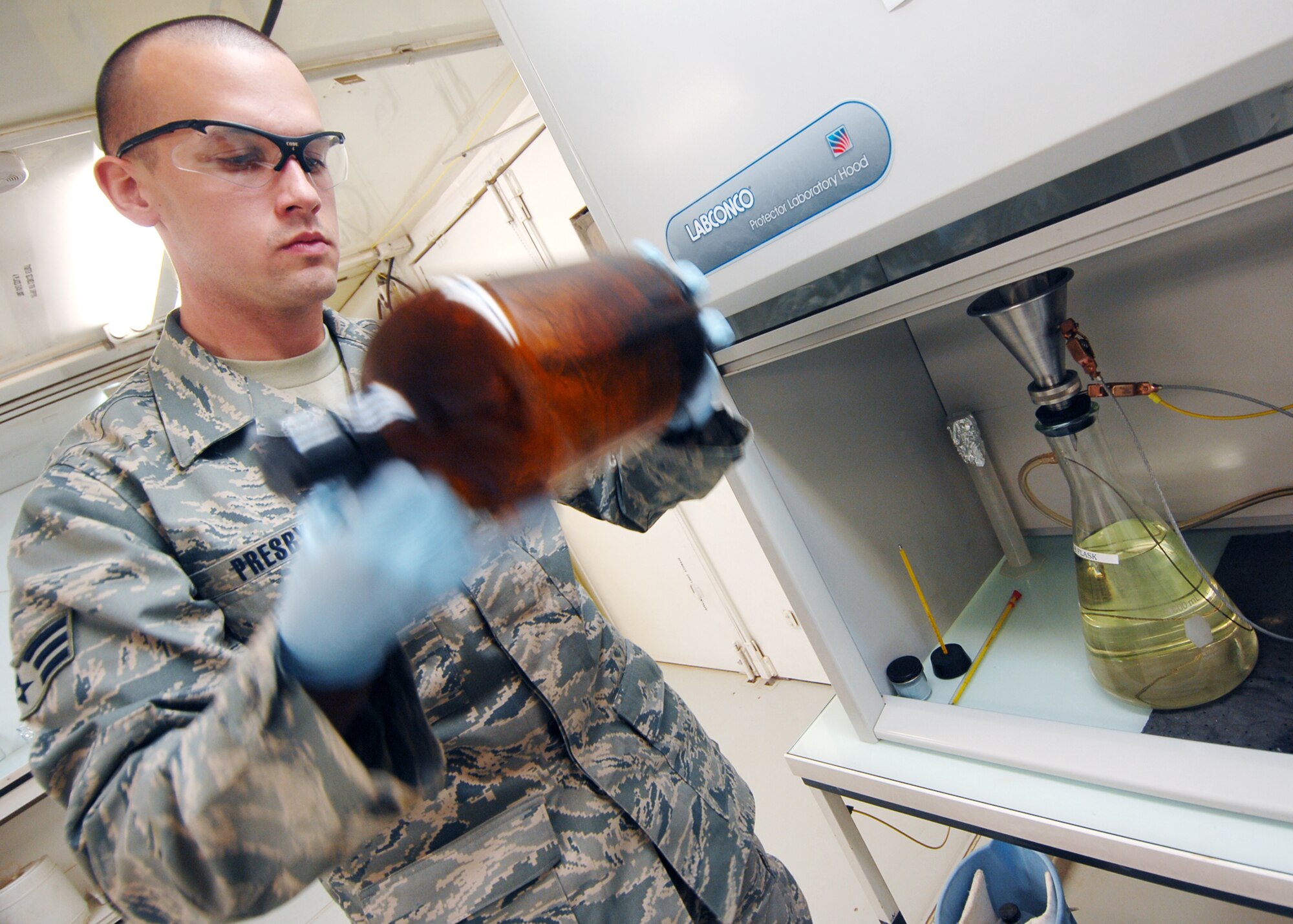 JOINT BASE BALAD, Iraq -- Senior Airman Matthew Presby, 332nd Expeditionary Logistics Readiness Squadron Fuels Lab technician, shakes a JP-8 jet fuel sample to keep sediment from collecting inside the bottle as part of the filtration process here Sept. 29, 2009. Airman Presby and other fuel lab technicians help ensure fuel is clean and ready for use in aircraft. (U.S. Air Force photo/Senior Airman Christopher Hubenthal)
