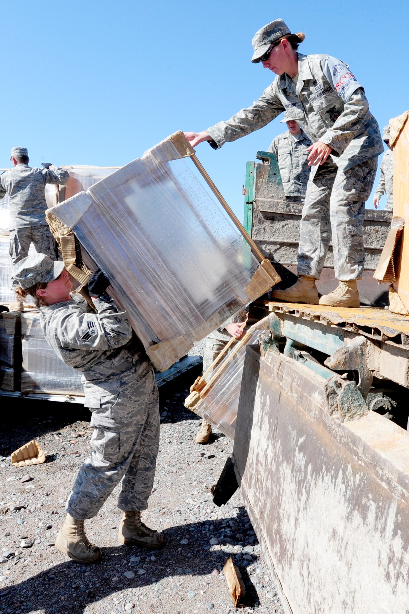 TRANSIT CENTER AT MANAS, Kyrgyzstan -- Senior Airman Kailey Simmons, 376th Expeditionary Force Support Squadron utility team member, hands a desk to Staff Sgt. Leslie Whiting, 376th Expeditionary Civil Engineer Squadron security escort, at the Transit Center. Sergeant Whiting is deployed from the 312th Training Squadron at Goodfellow Air Force Base, Texas, and is originally from Milbank, S.D. Airman Simmons is deployed from the 193rd FSS at Harrisburg International Airport, Pa. and is originally from Tamaqua, Pa. (U.S. Air Force photo/Senior Airman Steele C. G. Britton)