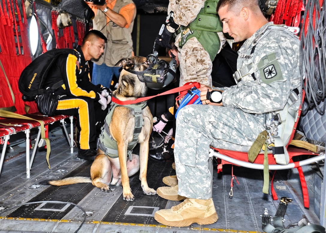 U.S. Army 1st Sgt. Chris Lalonde, right, with his military working dog, Sgt. Maj. Fasco, sit aboard a CH-47 Chinook helicopter just prior to taking off for the historical military’s first tandem airborne jump on Gammon Parade Field, on Fort Leonard Wood, Mo., Sept. 18, 2009. Lalonde is assigned to Company D, 701st Military Police Battalion.