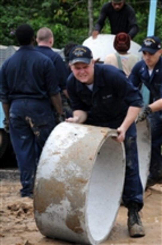 U.S. Navy Airman Thomas Curley, from the aircraft carrier USS Ronald Reagan (CVN 76), rolls a cement ring for a sewage tank during work for a Habitat for Humanity house in Phuket, Thailand, on Sept. 24, 2009.  The house is being built for a young girl who lost both parents in the 2004 tsunami and lives with her grandmother, who is severely arthritic.  While in Thailand, sailors participated in community relations projects.  The Ronald Reagan Carrier Strike Group is on deployment in the U.S. 7th Fleet area of responsibility.  