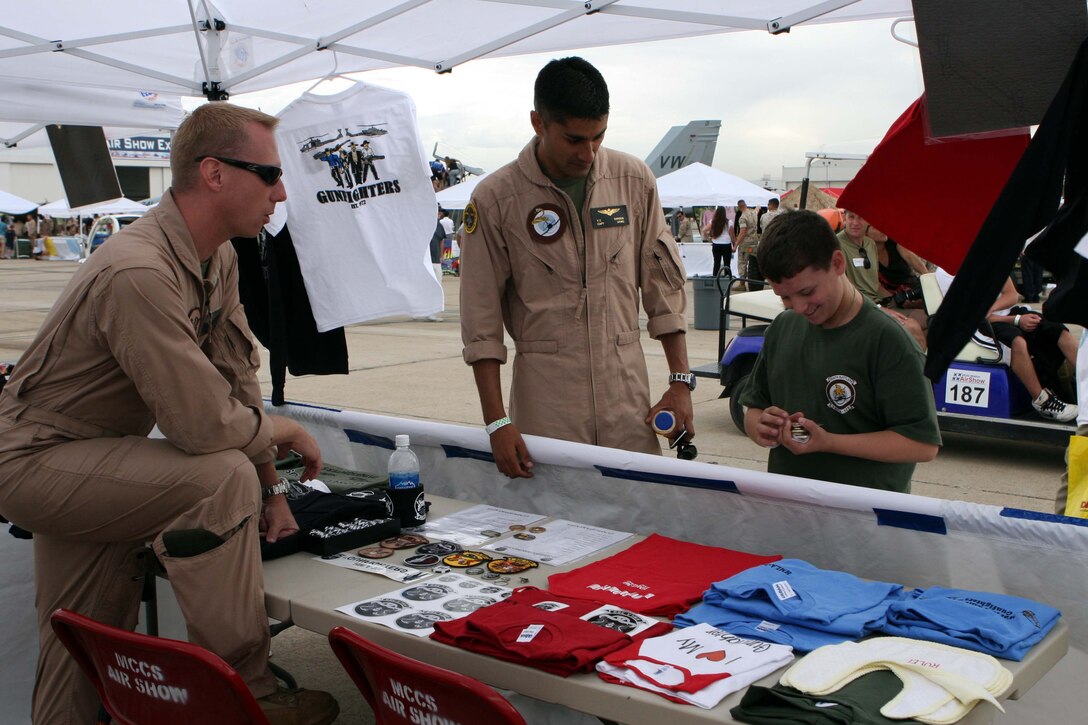 Capt. Taj Sareen, a Marine Fighter Attack Squadron 323 F/A-18 pilot, escorts Jared Hyams through the squadron booths collecting "challenge coins" at the 2009 Marine Corps Air Station Miramar Air Show Oct. 1. Jared and his family enjoyed the show and a tour of the air station courtesy of the Make-A-Wish Foundation, which helps fulfill the dreams of children with life-threatening medical conditions.