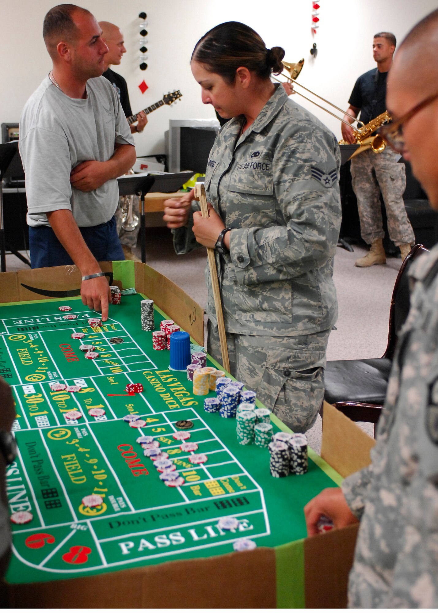 BAGRAM AIRFIELD, Afghanistan -- Senior Airman Cindy Jimenez, a Force Protection Airman from the 455th Expeditionary Civil Engineering Squadron, volunteers to be the stickman during a modified game of craps here Sept. 28, 2009.  The 455th Air Expeditionary Wing 5/6 club held Casino Night, which was a way to bring U.S. and Coalition Forces together for a morale boosting event.  The attendees were given play money to play games such as black jack, poker, craps and roulette.  The Staff and Technical Sergeants make up the 5/6 club who provide great ways to spread morale.  Airman Jimenez is deployed from the 87th Aeromedical/Dental Squadron from McGuire Air Force Base, N.J.  (U.S. Air Force photo/Senior Airman Felicia Juenke)