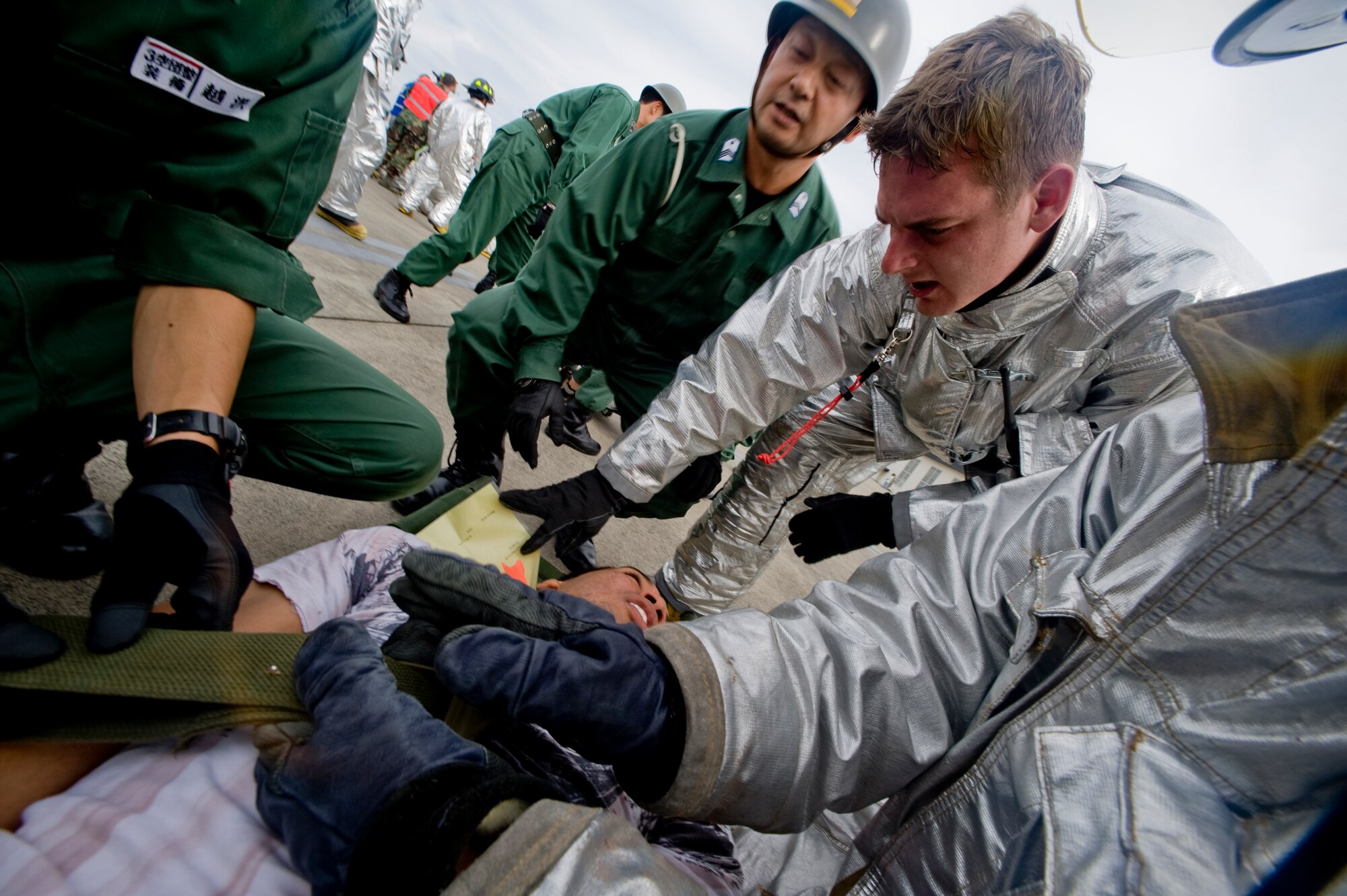 MISAWA AIR BASE, Japan -- Staff Sgt. Adam Mercer, 35th Civil Engineer Squadron crew chief, and Japan Air-Self Defense Force 3rd Air Wing first responders, tend to a simulated victim during a major accident response exercise Sept. 29 on the base flightline. The exercise was a joint effort by U.S. and Japan forces in an effort to prepare for the event of an aircraft mishap during the Misawa Air Festival scheduled for Oct. 18. (U.S. Air Force photo/Senior Airman Jamal D. Sutter)