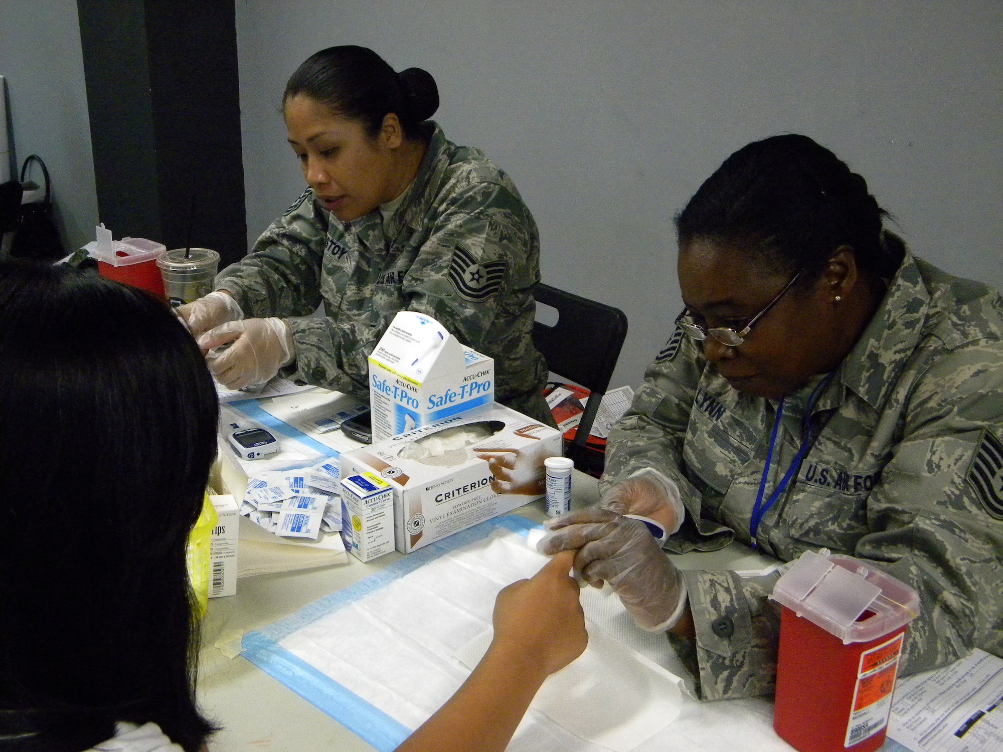 Tech. Sgts Mae Estoy and Zenobia Lynn, 724th Aeromedical Staging Flight, administer blood glucose tests during the annual National Preparedness Month activities held Sept. 26 at the Agana Shopping Center, Guam. (Courtesy photo)