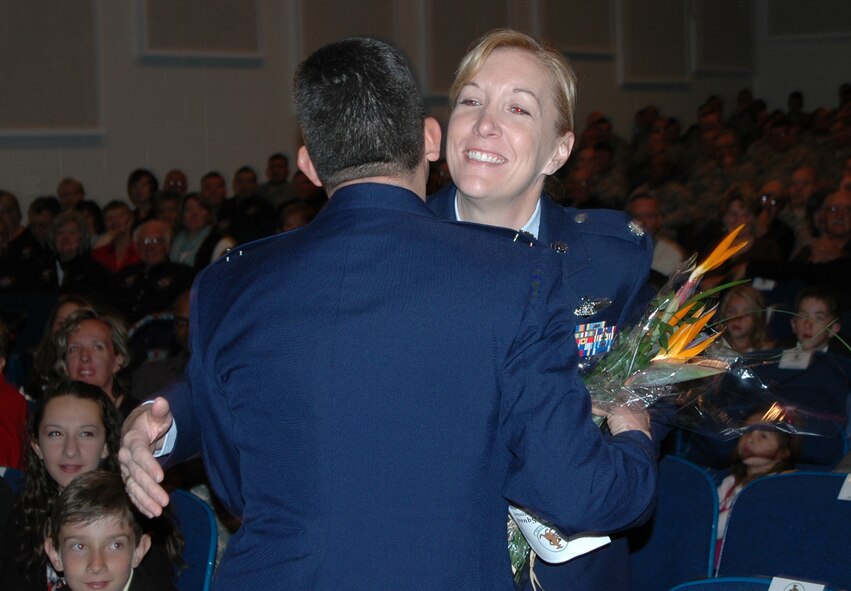 Lt. Col. Carlos Ortiz presents his wife, Lt. Col. Annette Ortiz, with a bouquet of flowers after he assumed command of the 52nd Airlift Squadron during an activation and assumption of command ceremony Oct. 3 at Peterson Air Force Base, Colo. The squadron is the Air Force's newest active association organization, that joins together Air Force Reserve and Active Duty Airmen to fly and maintain the same aircraft. Lt. Col. Annette Ortiz is an instructor at the U.S. Air Force Academy in Colorado Springs, Colo. (U.S. Air Force photo/Tech. Sgt. Daniel Butterfield)