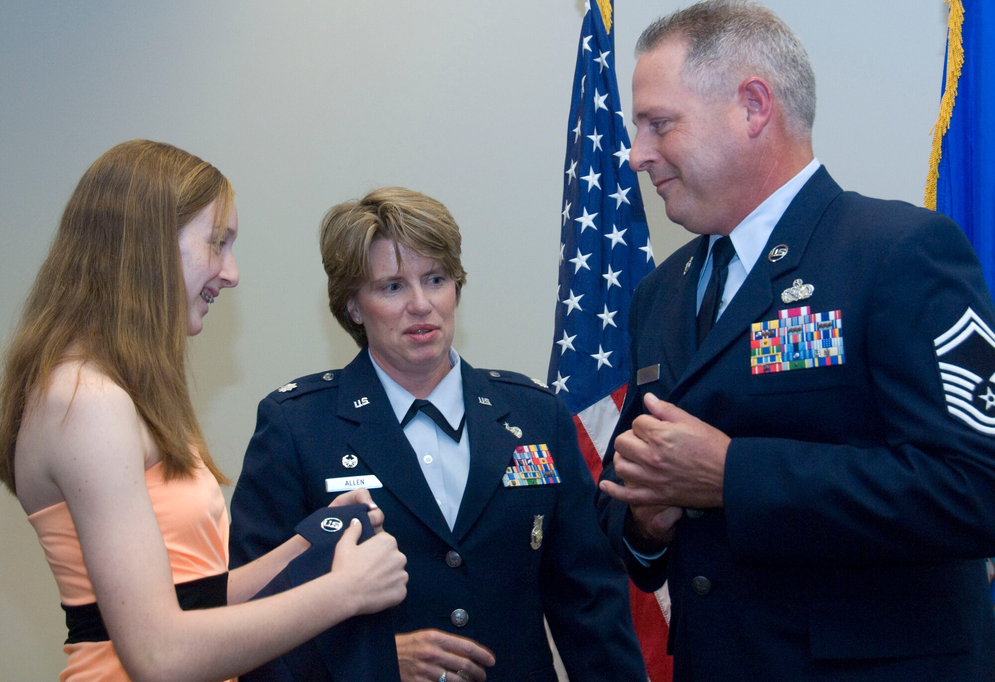 The newly-promoted Chief Master Sergeant Eugene "Lee" Wilcox, 403rd Civil Engineers Squadron, prepares to receive his blues service coat with his new chief rank from his daughter, Caroline. The promotion ceremony was held October 3 at the 403rd Maintenance Group's new Consolidated Aircraft Maintenance Facility.