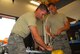 Munitions maitenance specialists Staff Sgt. Matt Hamilton (left) and Senior Airman James Jacobson assemble a AIM-9 Sidewinder missile.