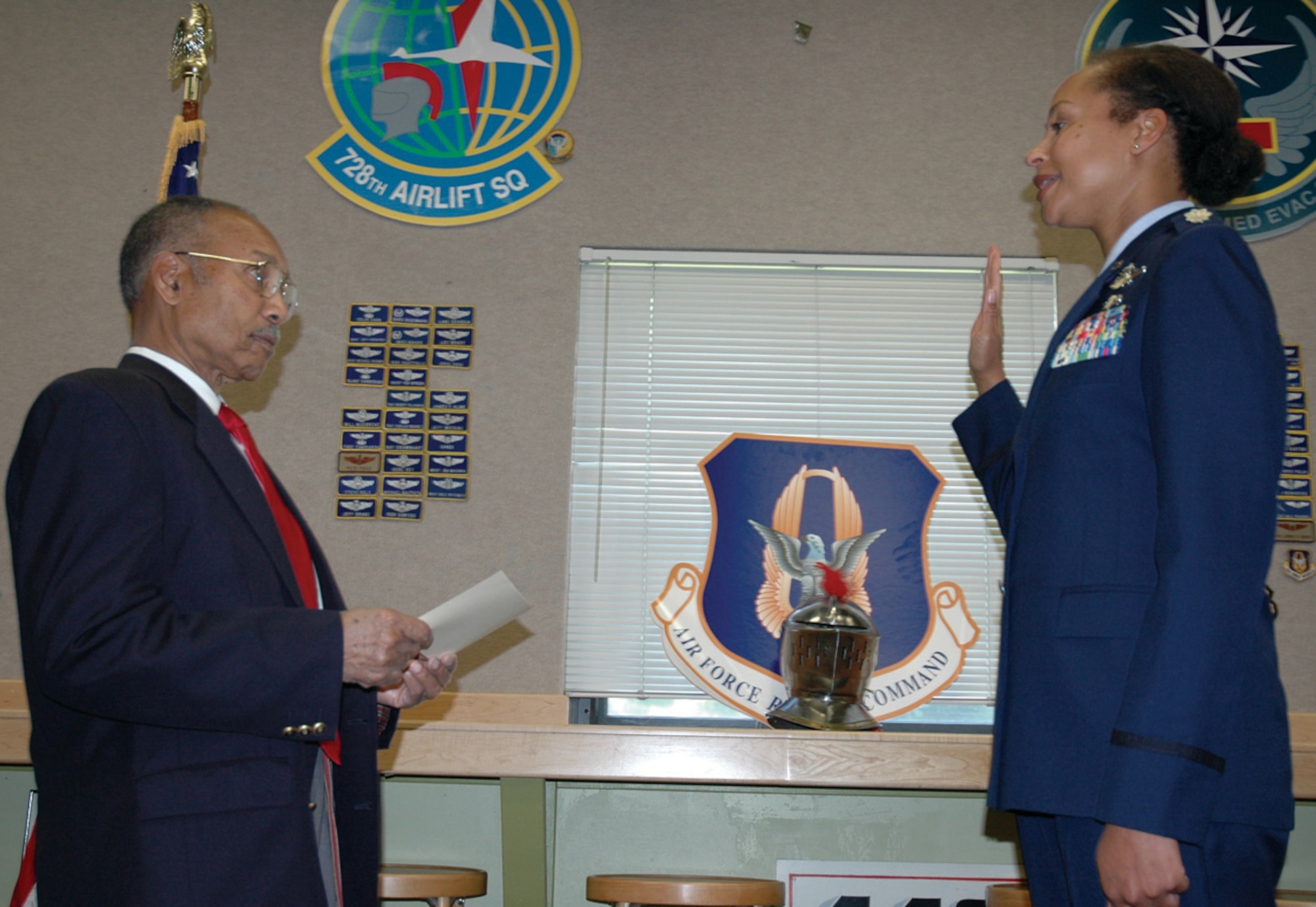 Retired Lt. Col. Edward Drummond, an original member of the Tuskegee Airmen, administers the oath of office to Lt. Col. Kimberly Scott, 728th Airlift Squadron, during her promotion ceremony October 3, 2009 at McChord Air Force Base. "Members of the Tuskegee Airmen have mentored, encouraged, and supported me over the years," said Colonel Scott. "It was incredibly meaningful to me to have been sworn in by Colonel Drummond."