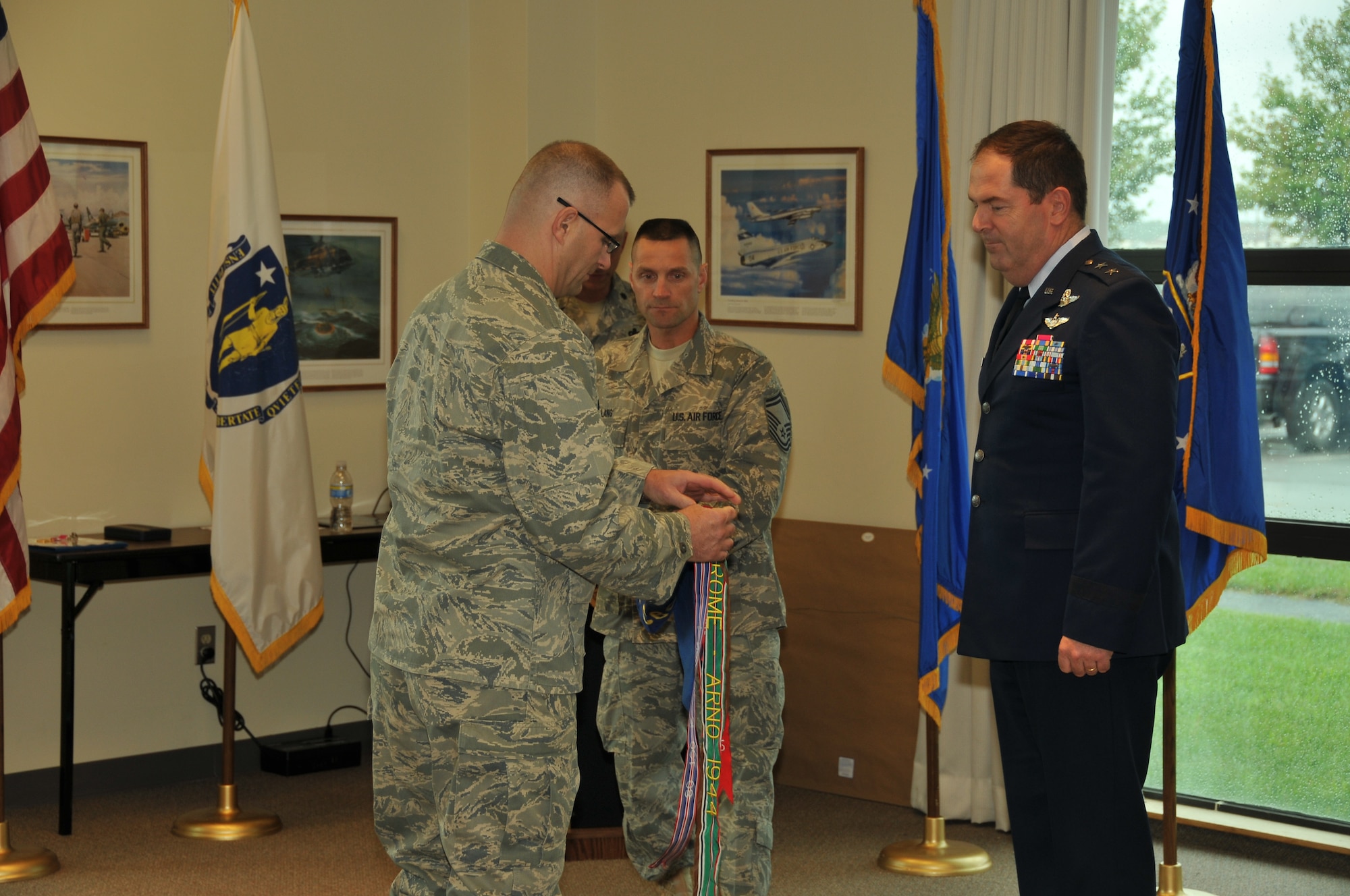 LtCol Joseph Morrissey, commander of the 267th Combat Communications Squadron places the Air Force Outstanding Unit Award on the squadron guide on held by SMSgt Francis Lang. LtCol Morrissey received the unit award from Maj. General Michael Akey, MA ANG Commander on October 3, 2009. US Air Force photo by TSgt Andrew Reitano
