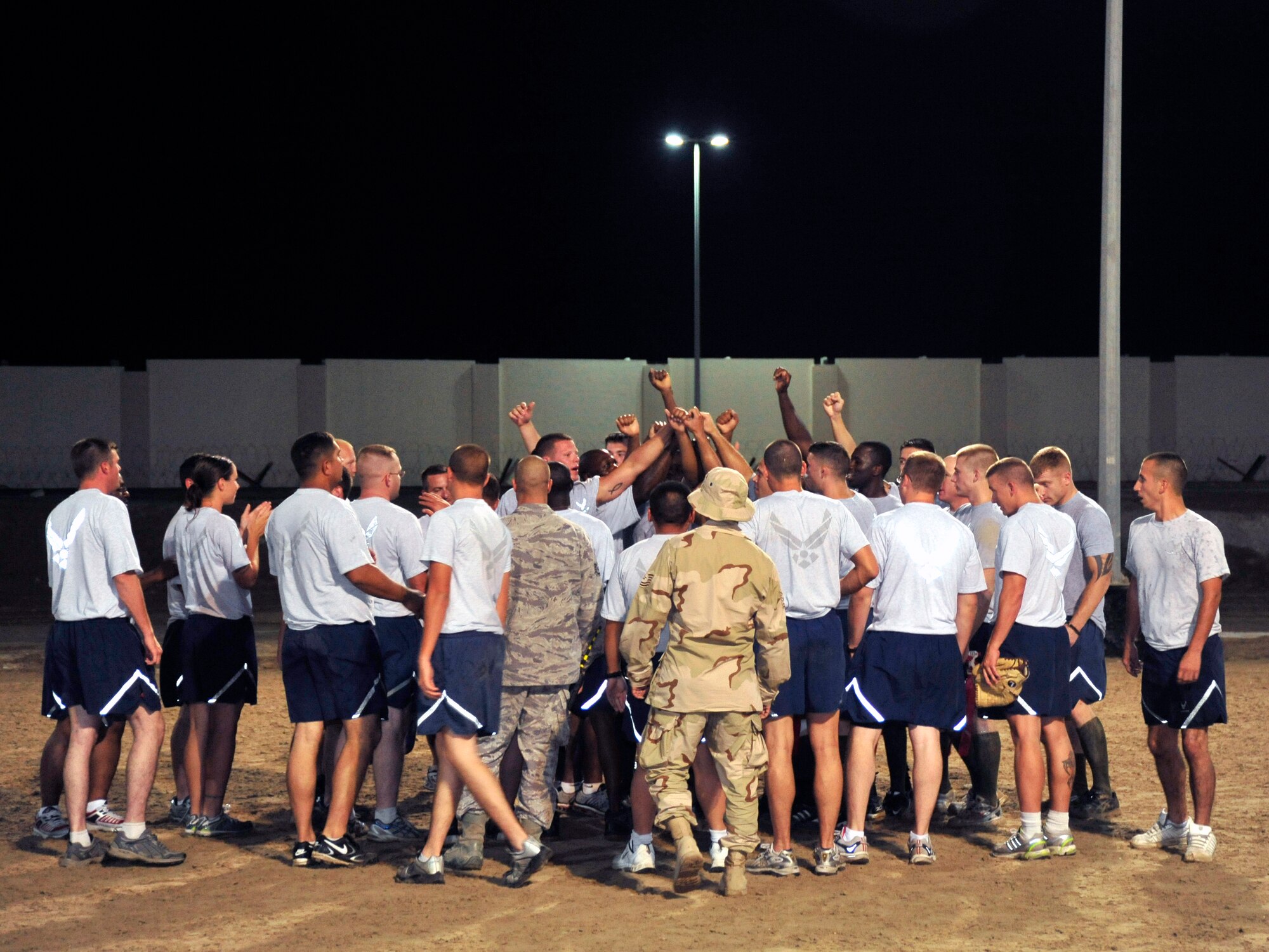 SOUTHWEST ASIA -Airmen from the 380th Expeditionary Civil Engineer Squadron gather to celebrate their victory in the flag football championship game here Oct. 1, 2009. The 380 ECES team finished with a final score of 13-6 over the 380th ECS. (U.S. Air Force photo/Tech. Sgt. Charles Larkin Sr)
