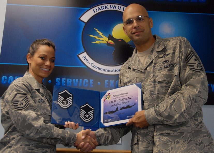 Newly promoted Master Sgt. Nikki Brace, 919th Communication Squadron, shows off her new stripes with Chief Master Sgt. Michael Klausutis, wing command chief, Oct. 3 at Duke Field.  Sergeant Brace was promoted via the Air Force Reserve’s Promotion Enhancement Program.  (U.S. Air Force photo/Staff Sgt. Samuel King Jr.)