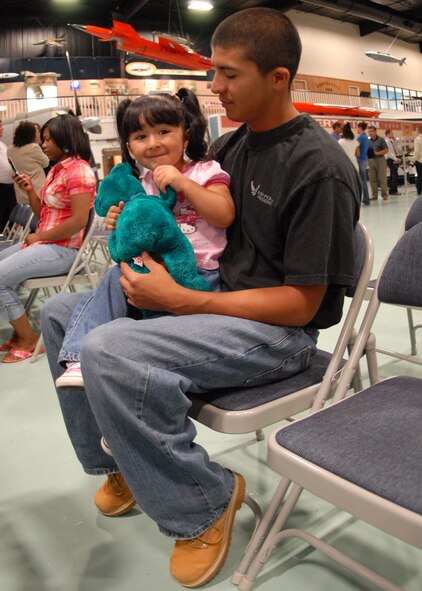 Adam Munoz holds his two-year-old daughter Kristina before the enlistment ceremony Oct. 3 at the Air Armament Museum.  Munoz is a new recruit to the Air Force and will ship out to basic training in March.  Munoz said he was looking forward to the whole experience and starting a new career.  (U.S. Air Force photo/Staff Sgt. Samuel King Jr.)