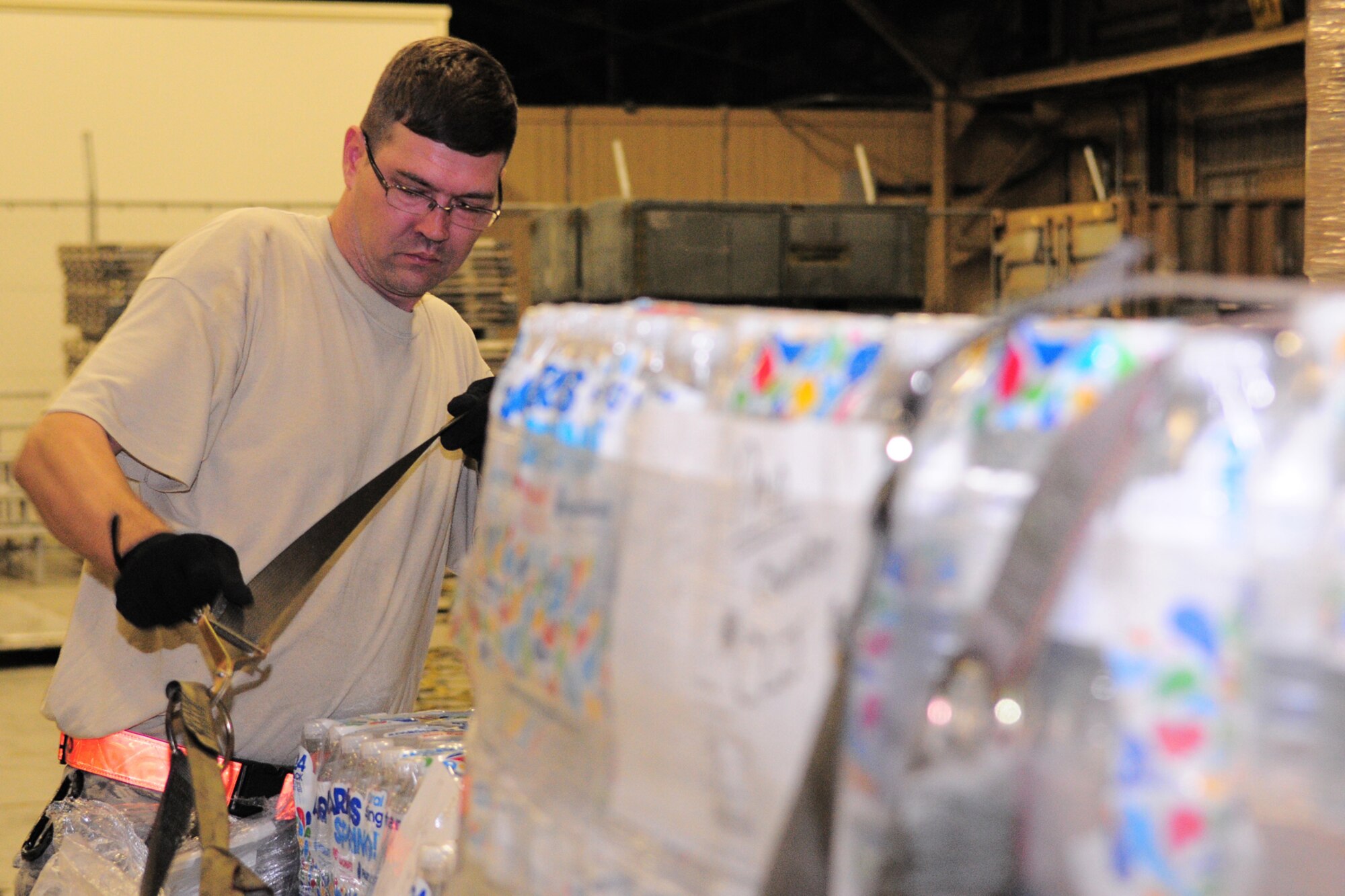 YOKOTA AIR BASE, Japan -- Tech. Sgt. Robert Davis, 374th Logistics Readiness Squadron, tightens the netting on a pallet of water Oct. 3 in support of the deployment of a U.S. Air Force Humanitarian Assistance Rapid Response Team to Padang, Indonesia. Sergeant Peters helped to build nine pallets totaling more than 35,000 pounds of equipment. The HARRT, which includes members from here and Andersen Air Force Base, Guam, is scheduled to depart Oct. 5 aboard a C-17 Globemaster III. (U.S. Air Force photo/Airman 1st Class Michael Dillon)