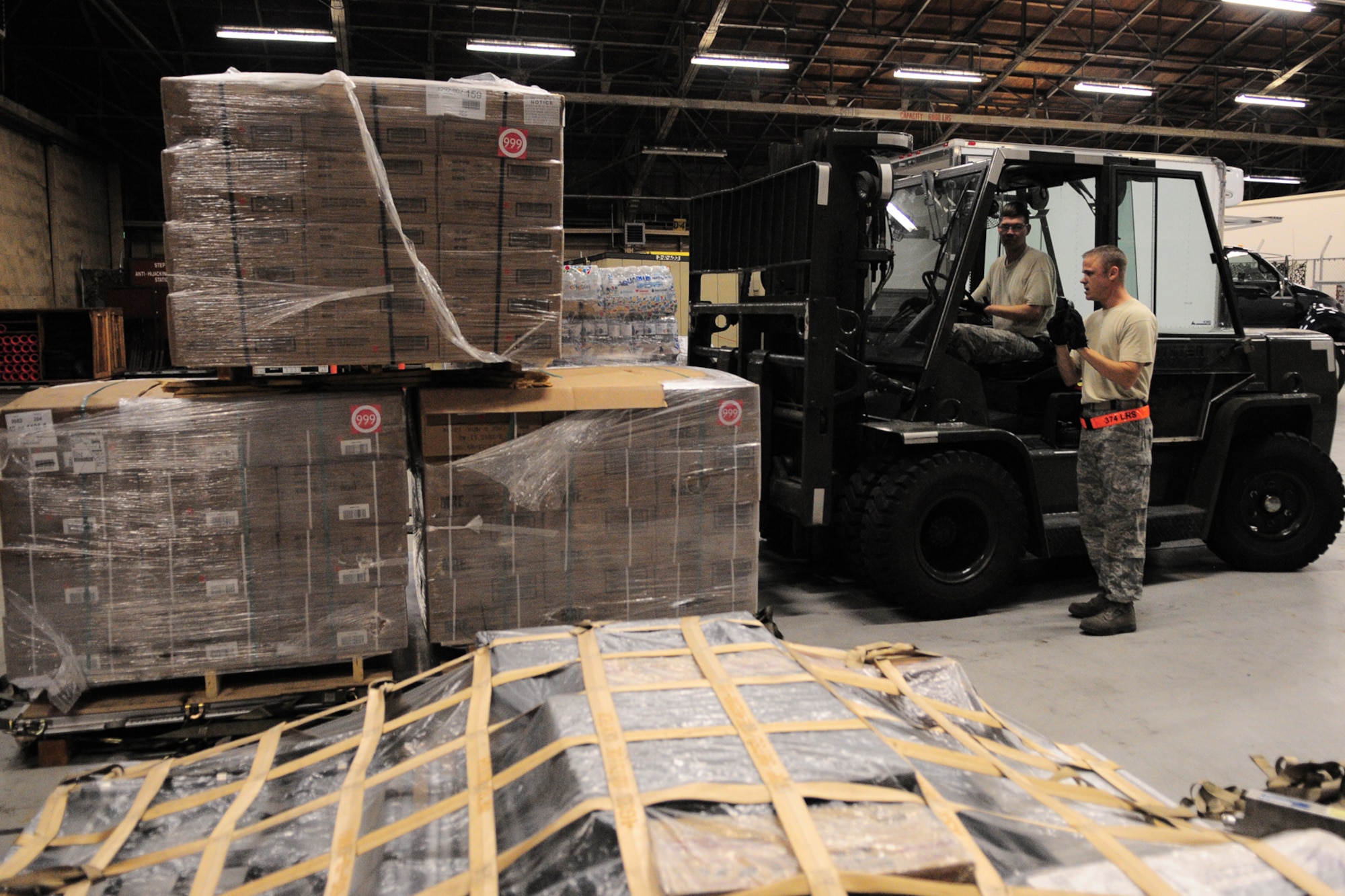YOKOTA AIR BASE, Japan -- Tech. Sgt. Chris Peters, 374th Logistics Readiness Squadron, guides Tech. Sgt. Robert Davis, Logistics Readiness Squadron as he stacks a pallet of supplies Oct. 3 in support of the deployment of a U.S. Air Force Humanitarian Assistance Rapid Response Team to Padang, Indonesia. Sergeant Peters helped to build nine pallets totaling more than 35,000 pounds of equipment. The HARRT, which includes members from here and Andersen Air Force Base, Guam, is scheduled to depart Oct. 5 aboard a C-17 Globemaster III. (U.S. Air Force photo/Airman 1st Class Michael Dillon)