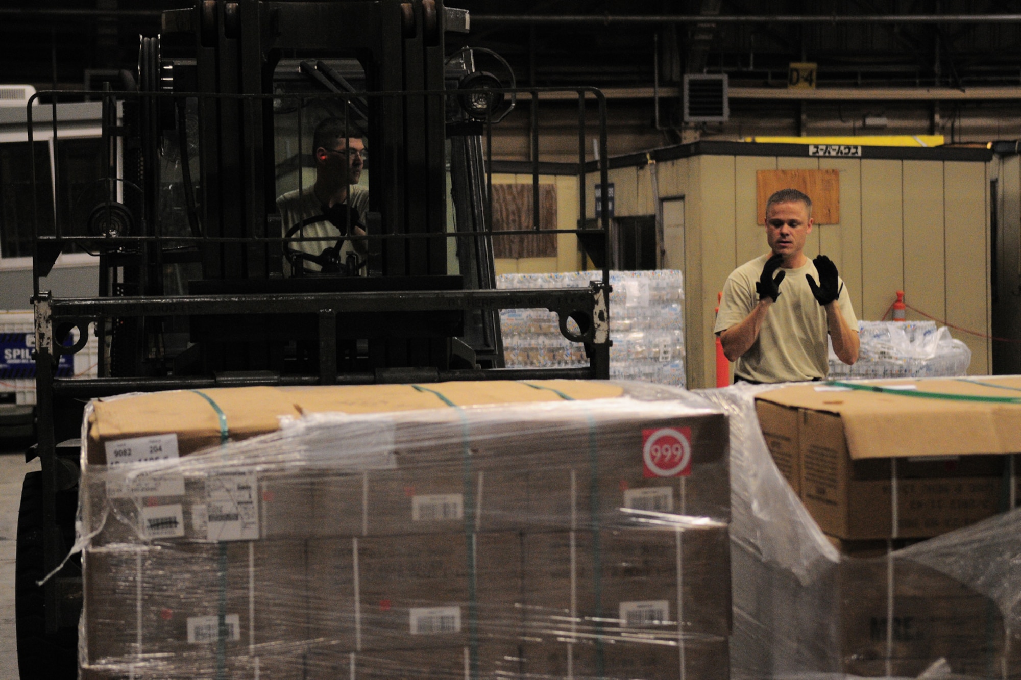 YOKOTA AIR BASE, Japan -- Tech. Sgt. Chris Peters, 374th Logistics Readiness Squadron, guides Tech. Sgt. Robert Davis, Logistics Readiness Squadron as he stacks a pallet of supplies Oct. 3 in support of the deployment of a U.S. Air Force Humanitarian Assistance Rapid Response Team to Padang, Indonesia. Sergeant Peters helped to build nine pallets totaling more than 35,000 pounds of equipment. The HARRT, which includes members from here and Andersen Air Force Base, Guam, is scheduled to depart Oct. 5 aboard a C-17 Globemaster III. (U.S. Air Force photo/Airman 1st Class Michael Dillon)