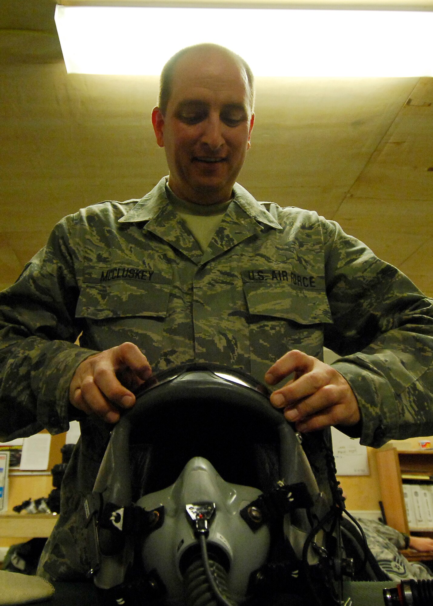 BAGRAM AIRFIELD, Afghanistan -- Technical Sgt. William McCluskey, an aircrew flight equipment Airman from the 774th Expeditionary Airlift Squadron, attaches the visor to the pilot's helmet after cleaning it here, Oct. 4, 2009.  Routine inspections are performed monthly on the helmets and they are cleaned after every use.  Sergeant McCluskey, a Mineral Wells, Texas native, is deployed from the Texas Air National Guard's 136th Airlift Wing.  (U.S. Air Force photo/Senior Airman Felicia Juenke)