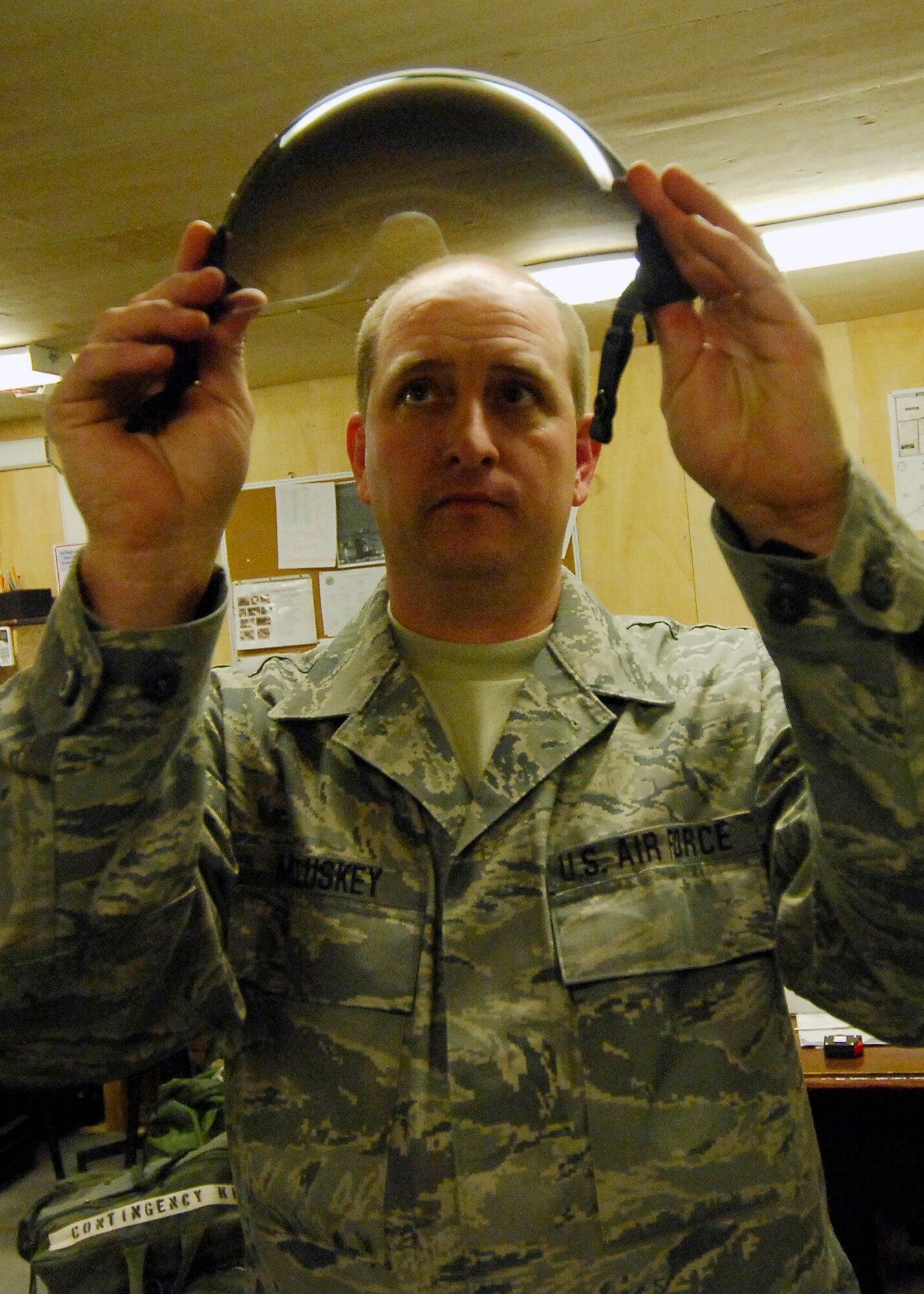 BAGRAM AIRFIELD, Afghanistan -- Technical Sgt. William McCluskey, an aircrew flight equipment Airman from the 774th Expeditionary Airlift Squadron, ensures there are no cracks in the visor of the pilot's helmet here, Oct. 4, 2009.  Routine inspections are performed monthly on the helmets and they are cleaned after every use.  Sergeant McCluskey, a Mineral Wells, Texas native, is deployed from the Texas Air National Guard's 136th Airlift Wing.  (U.S. Air Force photo/Senior Airman Felicia Juenke)