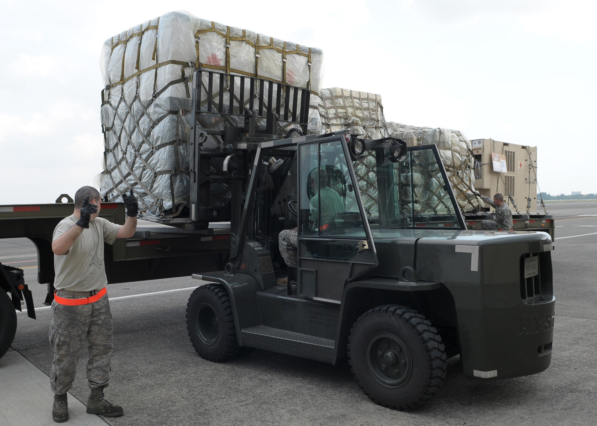 YOKOTA AIR BASE, Japan -- Airman 1st Class Alexander Torelli, 374th Maintenance Squadron, spots Senior Airman Jonathon Fleck, 374th MXS, as they download a pallet of medical supplies Oct. 4 to support the deployment of a U.S. Air Force Humanitarian Assistance Rapid Response Team to Padang, Indonesia. Medical personnel here built nine pallets totaling more than 35,000 pounds of equipment. The HARRT, which includes members from here and Andersen Air Force Base, Guam, is scheduled to depart Oct. 5 aboard a C-17 Globemaster III. (U.S. Air Force photo/Airman 1st Class Sean Martin)

