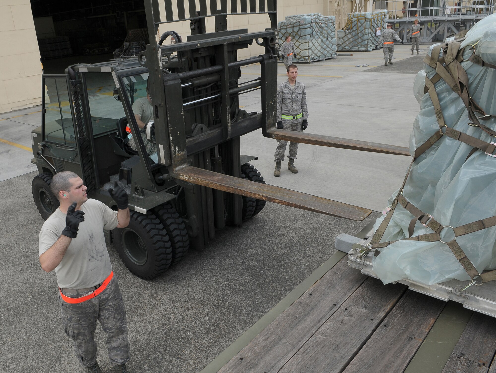 YOKOTA AIR BASE, Japan -- Airman 1st Class Alexander Torelli, 374th Maintenance Squadron, spots Senior Airman Jonathon Fleck, 374th MXS, as they download a pallet of medical supplies Oct. 4 to support the deployment of a U.S. Air Force Humanitarian Assistance Rapid Response Team to Padang, Indonesia. Medical personnel here built nine pallets totaling more than 35,000 pounds of equipment. The HARRT, which includes members from here and Andersen Air Force Base, Guam, is scheduled to depart Oct. 5 aboard a C-17 Globemaster III. (U.S. Air Force photo/Airman 1st Class Sean Martin)

