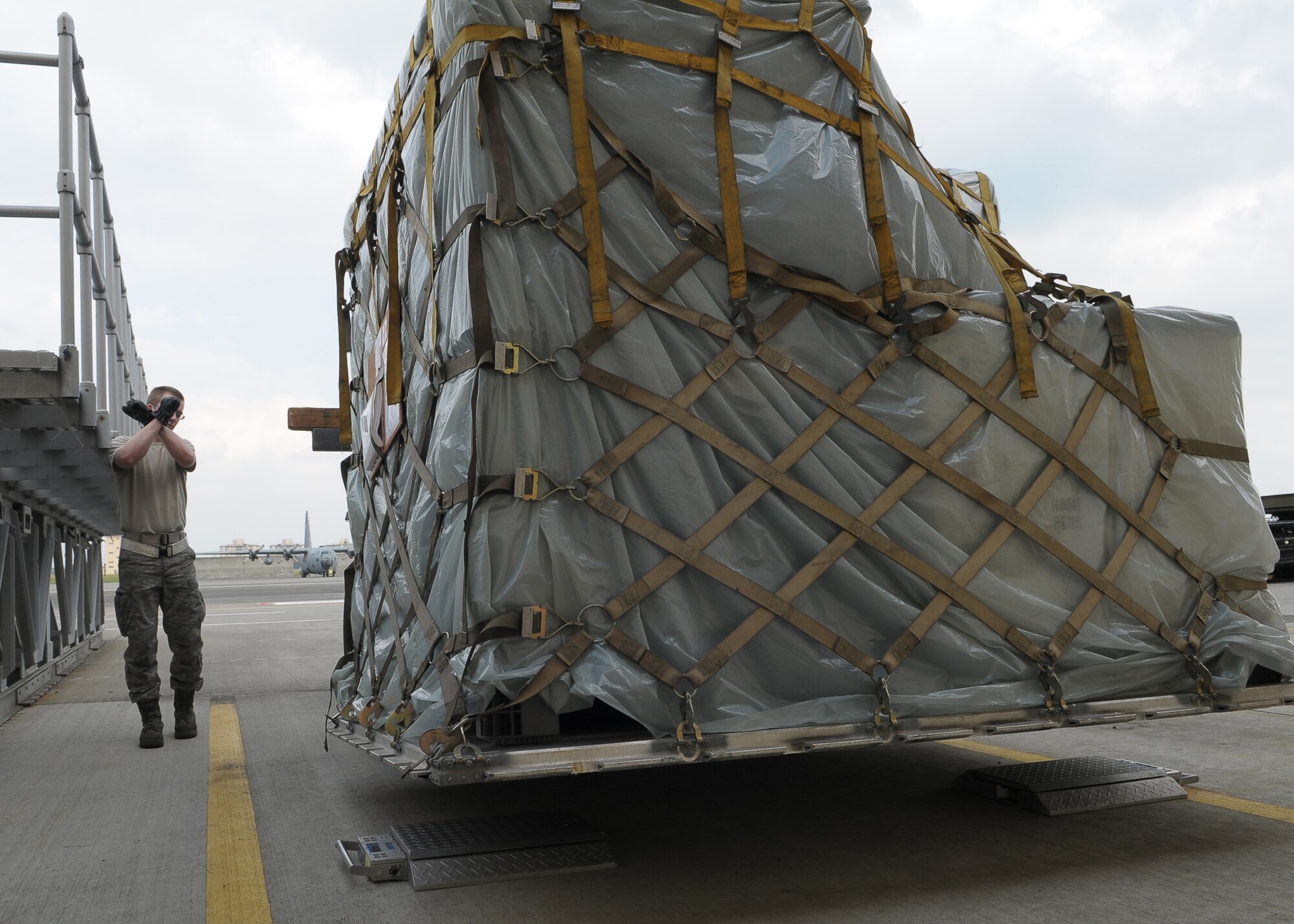 YOKOTA AIR BASE, Japan -- Airman 1st Class James Kliever, 374th Maintenance Squadron, spots Staff Sgt. Johnathan Marker, 374th Logistics Readiness Squadron, as they prepare to weigh a pallet of medical supplies Oct. 4 in support of the deployment of a U.S. Air Force Humanitarian Assistance Rapid Response Team to Padang, Indonesia. Medical personnel here built nine pallets totaling more than 35,000 pounds of equipment. The HARRT, which includes members from here and Andersen Air Force Base, Guam, is scheduled to depart Oct. 5 aboard a C-17 Globemaster III. (U.S. Air Force photo/Airman 1st Class Sean Martin)


