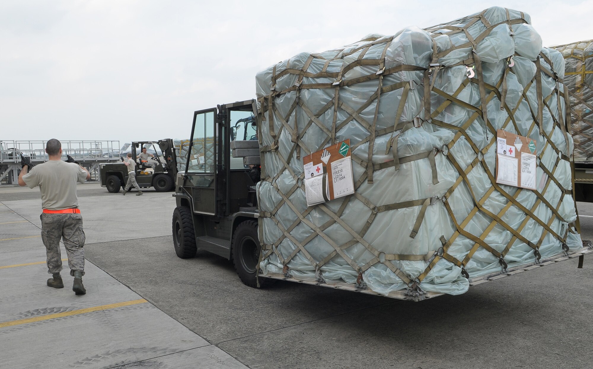 YOKOTA AIR BASE, Japan -- Airman 1st Class Alexander Torelli, 374th Maintenance Squadron, spots Senior Airman Jonathon Fleck, 374th MXS, as they download a pallet of medical supplies Oct. 4 to support the deployment of a U.S. Air Force Humanitarian Assistance Rapid Response Team to Padang, Indonesia. Medical personnel here built nine pallets totaling more than 35,000 pounds of equipment. The HARRT, which includes members from here and Andersen Air Force Base, Guam, is scheduled to depart Oct. 5 aboard a C-17 Globemaster III. (U.S. Air Force photo/Airman 1st Class Sean Martin)

