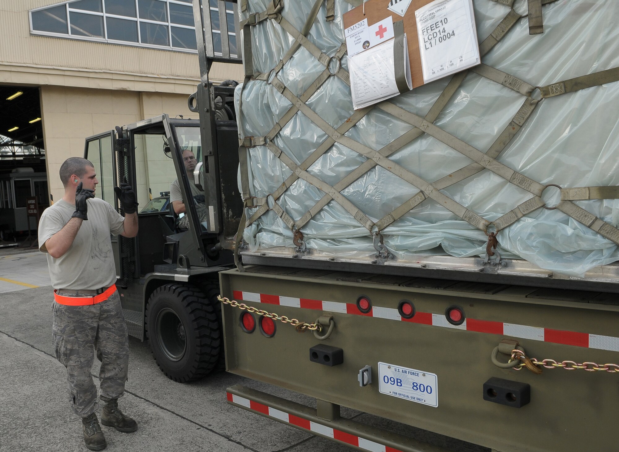 YOKOTA AIR BASE, Japan -- Airman 1st Class Alexander Torelli, 374th Maintenance Squadron, (left) spots Senior Airman Jonathon Fleck, 374th MXS, as they download a pallet of medical supplies Oct. 4 to support the deployment of a U.S. Air Force Humanitarian Assistance Rapid Response Team to Padang, Indonesia. Medical personnel here built nine pallets totaling more than 35,000 pounds of equipment. The HARRT, which includes members from here and Andersen Air Force Base, Guam, is scheduled to depart Oct. 5 aboard a C-17 Globemaster III. (U.S. Air Force photo/Airman 1st Class Sean Martin)

