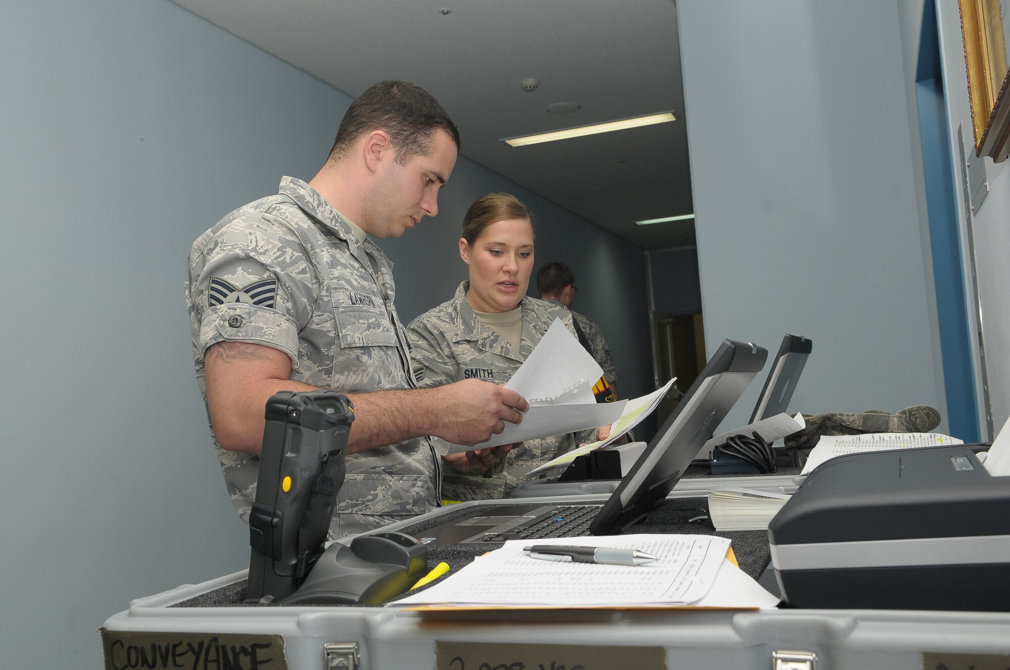 YOKOTA AIR BASE, Japan -- Staff Sgt. Richard Lawhorn, from 374th Communication Squadron, and Senior Amn. Kayla Smith, from the 374th Maintenance Operations Squadron, look over a passenger manifest Oct 4 as part of a noncombatant evacuation operations exercise. The exercise tested Yokota's noncombatant reception control center's ability to account for and process the noncombatants. (U.S. Air Force photo/Airman 1st Class Sean Martin)