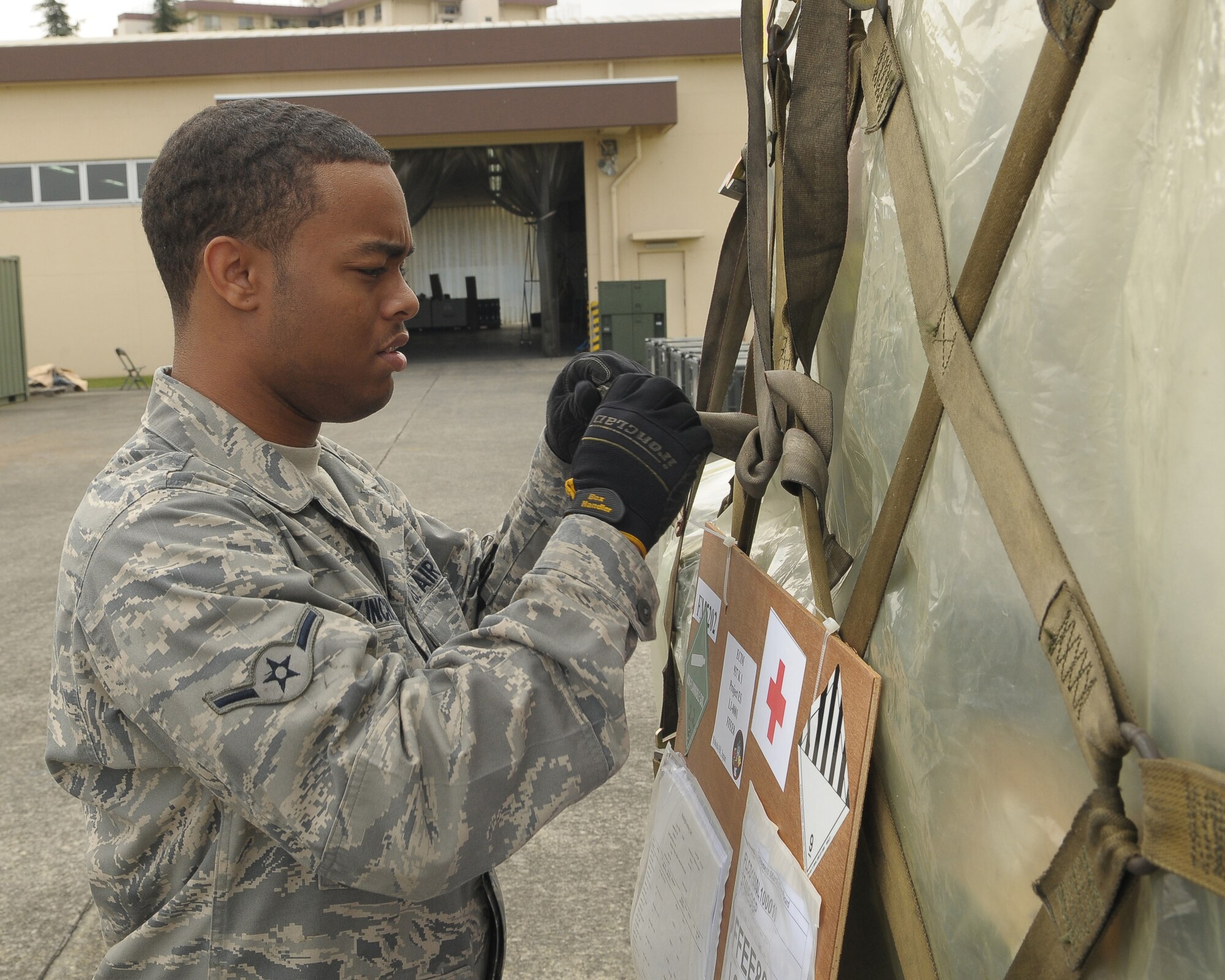 YOKOTA AIR BASE, Japan -- Airman Steven Kinchlow, 374th Medical Support Squadron medical material technician, tightens down the cargo netting on a pallet of medical supplies Oct. 4 to support the deployment of a U.S. Air Force Humanitarian Assistance Rapid Response Team to Padang, Indonesia. Airman Kinchlow helped to build nine pallets totaling more than 35,000 pounds of equipment. The HARRT, which includes members from here and Andersen Air Force Base, Guam, is scheduled to depart Oct. 5 aboard a C-17 Globemaster III. (U.S. Air Force photo/Airman 1st Class Sean Martin)