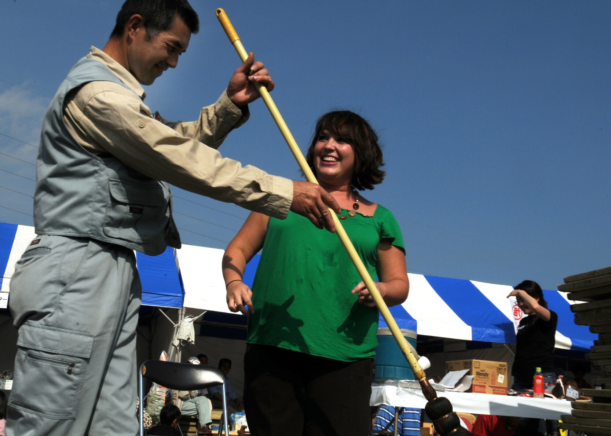 Mr. Masanori Kobashi shows Ms. Beth Gosselin, Chief of Public Affairs Operations at Kadena Air Base, Japan, how to paint her name with a hitofudegaki (large paint brush) at a local farm festival during their visit to Hyakuri Air Base, Japan, Oct. 04. The squadron is participating in an Aviation Training Relocation exercise between the U.S. Air Force and the Japan Air Self Defense Force from Oct. 5-9, 2009.
