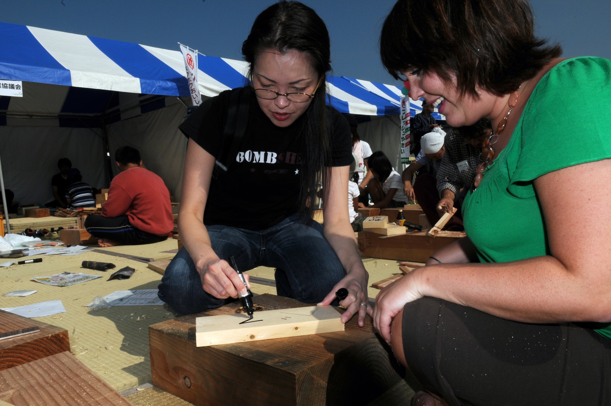 Mrs. Sayaka Higa, media relations specialist and Ms. Beth Gosselin, Chief of Public Affairs Operations, both at Kadena Air Base, Japan, try their wood-working skills at a local farm festival during their visit to Hyakuri Air Base, Japan, Oct. 04. The squadron is participating in an Aviation Training Relocation exercise between the U.S. Air Force and the Japan Air Self Defense Force from Oct. 5-9, 2009.