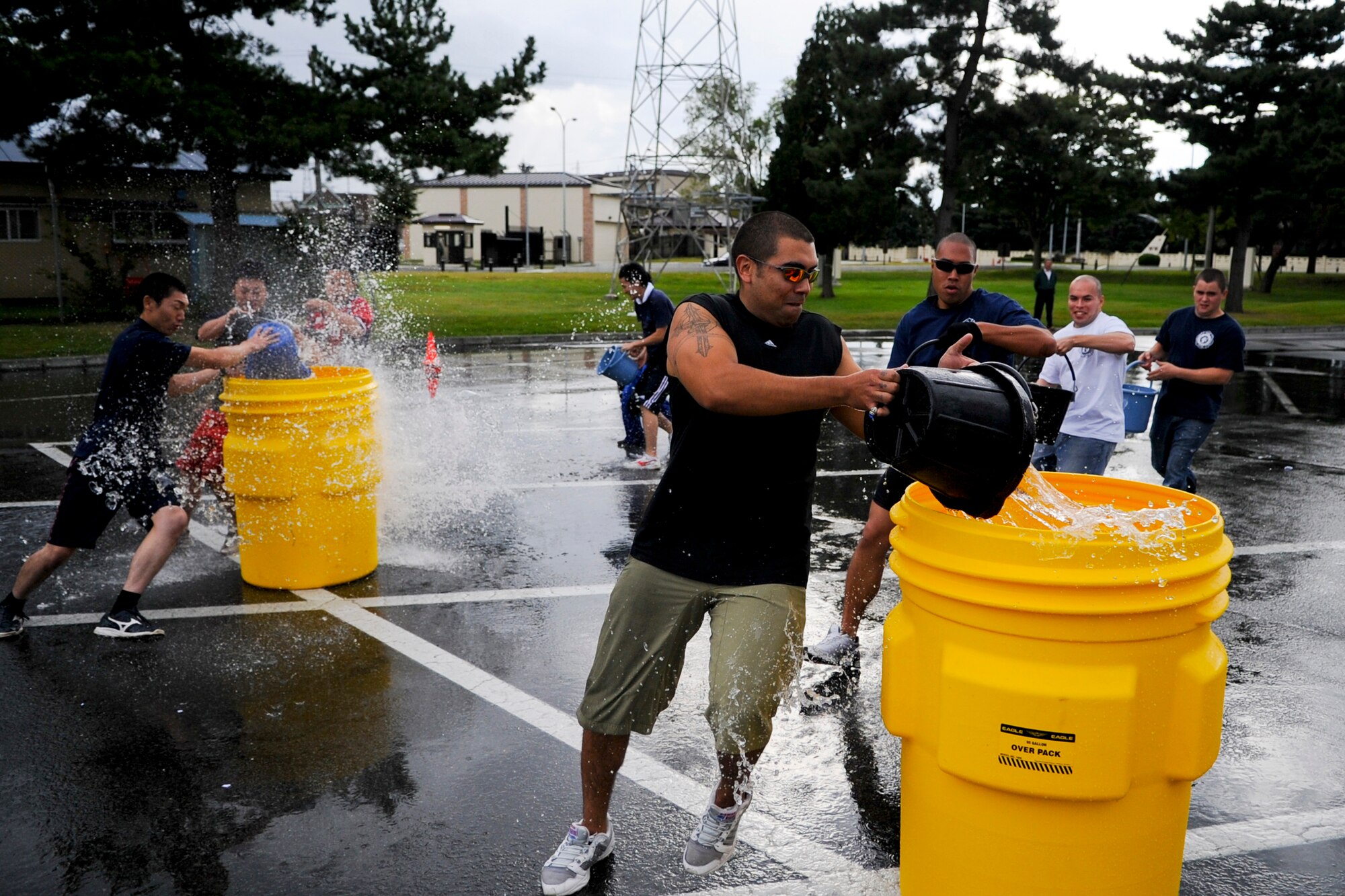 MISAWA AIR BASE, Japan -- The 35th Civil Engineer Squadron fire department's A-shift team races against the Towada City fire department's C-team in a bucket brigade competition during the Misawa Air Base Fire Muster Oct. 4 at the Base Exchange. The 35th Civil Engineer Squadron fire department's A-shift team won the round, while the Towada fire department's A-team took first place in the bucket brigade as well as the overall muster event. (U.S. Air Force photo by Senior Airman Jamal D. Sutter)