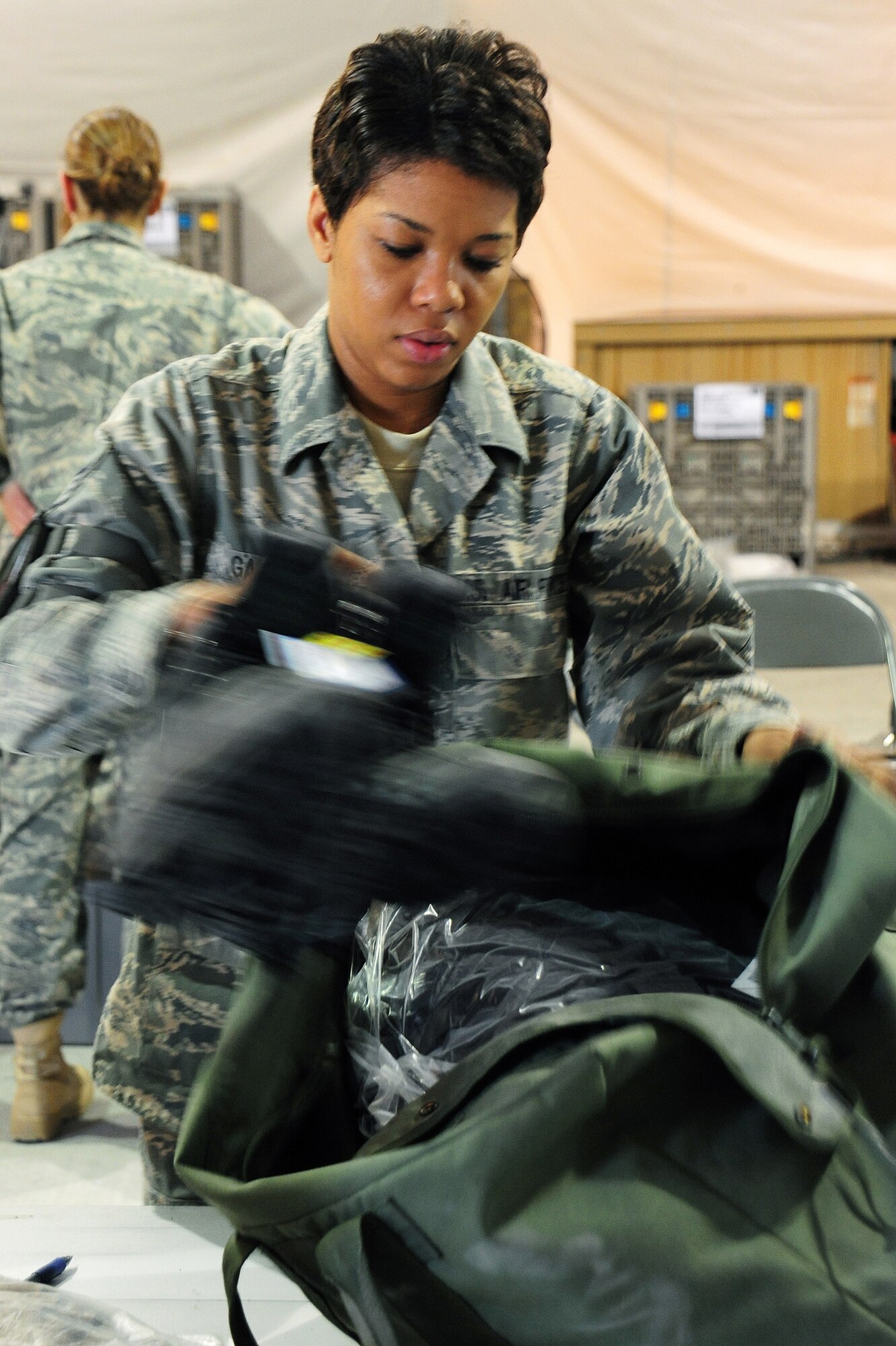 Staff Sgt. Kishima Garcia, 376th Expeditionary Logistics Readiness Squadron, packs a bag with cold weather gear at the Expeditionary Theater Distribution Center on Manas Air Base, Kyrgyzstan. Sergeant Garcia, non-commissioned officer in charge of stock control, ensures transient Airmen are provided the necessary gear before deploying to the area of responsibility. She is deployed from the 354th Logistics Readiness Squadron at Eielson Air Force Base, Alaska. Sergeant Garcia is originally from St. Croix, U.S. Virgin Islands. (U.S. Air Force photo/Senior Airman Steele Britton)