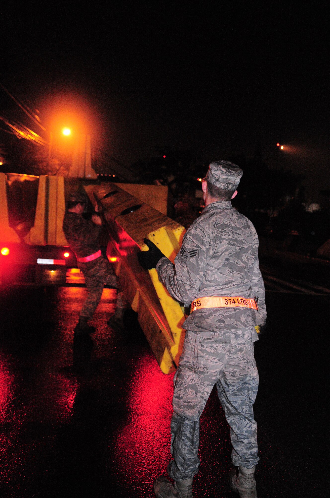 YOKOTA AIR BASE, Japan -- Airmen from the 374th Airlift Wing lift a portable barrier onto the back of a flatbed truck for distribution throughout the base in response to a simulated increase in the force protection posture during Beverly-Bearcat 09-05, an operational readiness inspection conducted by the Pacific Air Forces Inspector General. (U.S. Air Force photo/Airman 1st Class Michael Dillon)