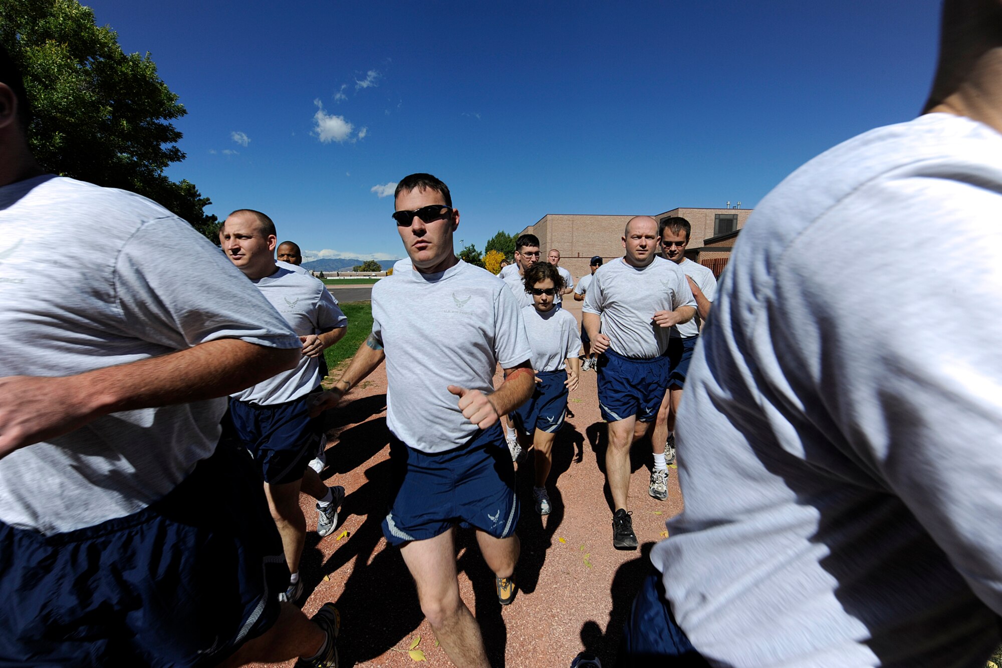PETERSON AIR FORCE BASE, Colo. -- Airmen rush past the starting point during the Combined Federal Campaign Awareness Run Sept. 29. Organized by Les Stewart, 21st Force Support Squadron, and Stephanie Edquid, 21st Space Wing Local Federal Coordinating Committee, the 5K run began and ended at the base fitness center. The 45 participants were rewarded with free ice cream and CFC T-shirts. The CFC is the only authorized solicitation of employees in the federal government workplace on behalf of charitable organizations, and the 21st SW’s fundraising goal this year is $248,000. For more information on the campaign, call Ms. Edquid at 556-1587 or contact a 21st SW CFC representative. (Air Force photo by Rob Bussard)