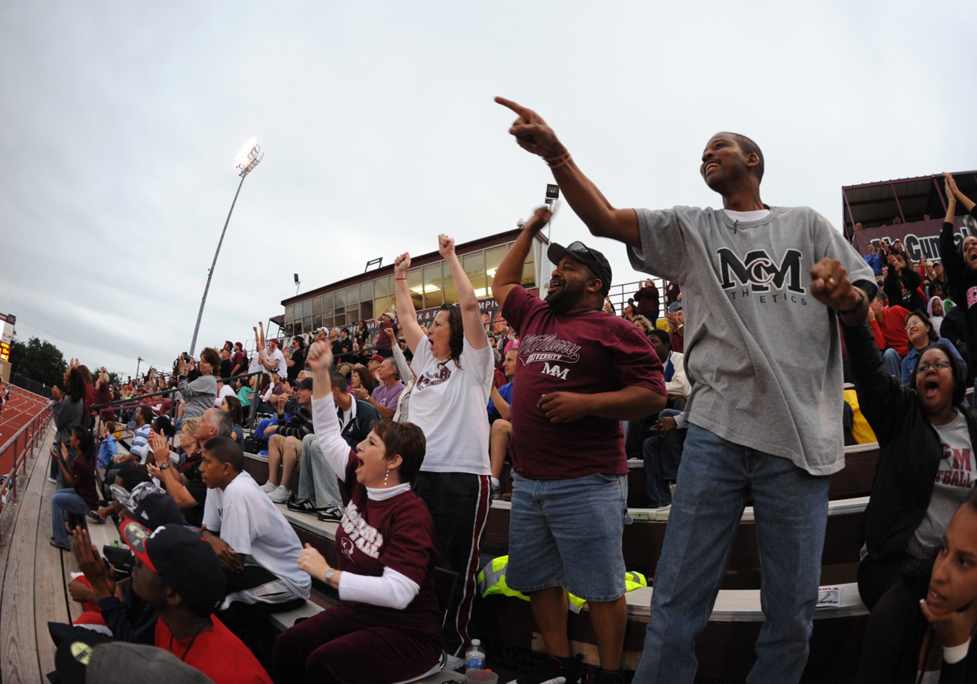 Abilene, Texas -- Dyess Air Force Base military members and McMurray University fans cheer during Military Appreciation Day here, Oct. 3. Military members and their families were honored guest  with free food, a tailgate party, free game entry to the McMurray University versus East Texas Baptist University football game.  McMurray ended a 17 game losing streak and beat East Texas Baptist University for the first time since 1948. ( U.S. Air Force photo by Senior Airmen Jenifer H. Calhoun)