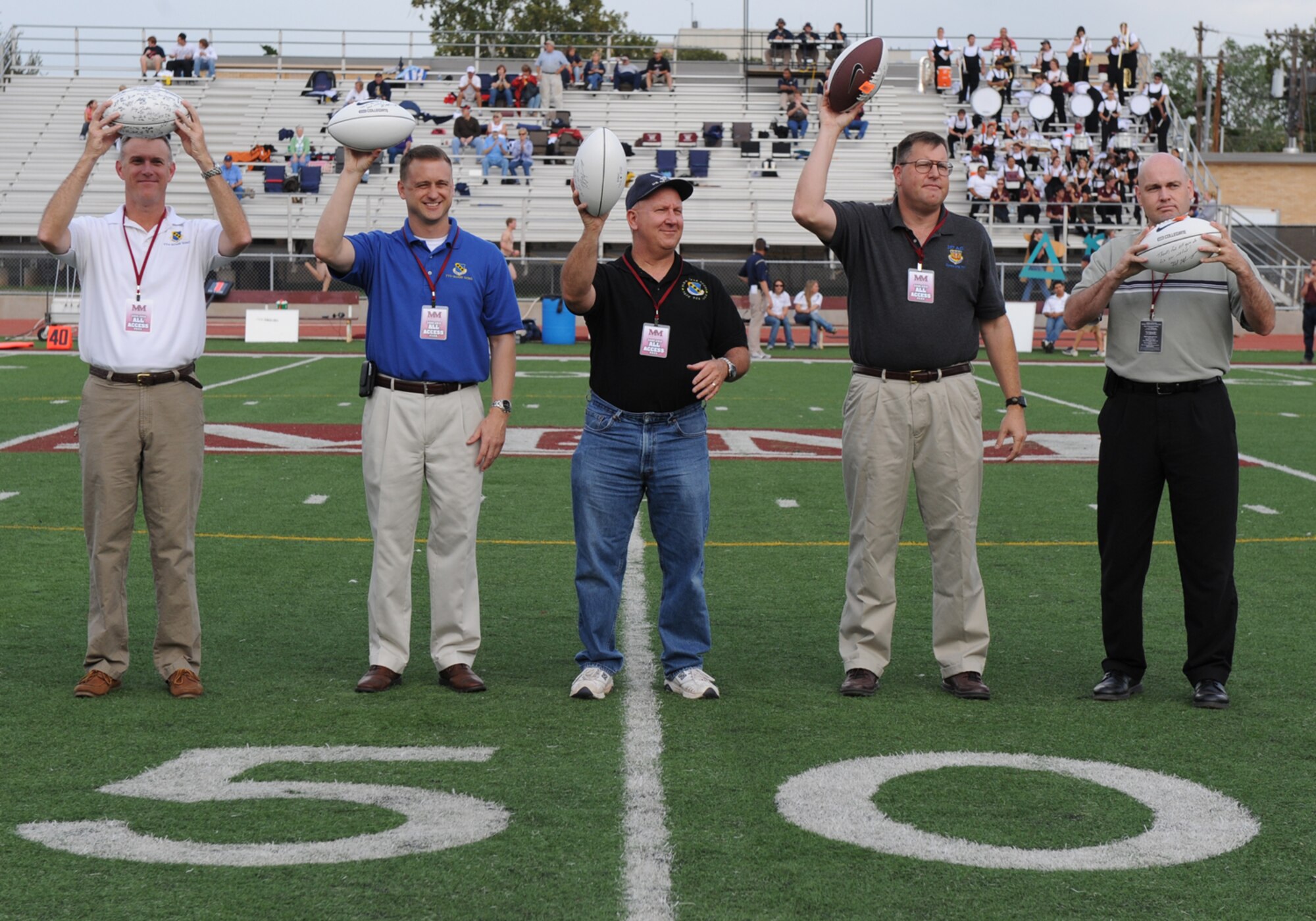 Abilene, Texas -- (Left to Right) Colonel  Robert Gass, 7th Bomb Wing Commander, Colonel  Ken Tatum, 7th Bomb Wing Vice Commander, Colonel Jim Murray, 7th Mission Support Group Commander, Colonel Bernie Mater, 317th Air Group Commander and Captain James Galyon, a  7th Bomb Wing chaplain, hold up “game balls” signed by the McMurry University football team at Wilford Moore Stadium during Military Appreciation Day here, Oct. 3. Military members and their families were honored guest with free food, a tailgate party, free game entry to the McMurray University versus East Texas Baptist University football game.  McMurray ended a 17 game losing streak and beat East Texas Baptist University for the first time since 1948. ( U.S. Air Force photo by Senior Airmen Jenifer H. Calhoun)