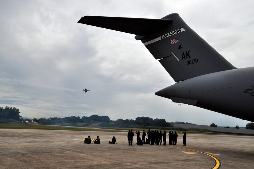 Maintainers from the Royal Malaysian Air Force find shade under a C-17 Globemaster III from Elmendorf Air Force Base, Alaska, during the Thunderbirds air show in Kuala Lumpur, Malaysia, Oct. 3. The Elmendorf C-17 crew and another from Hickam Air Force Base, Hawaii, are tasked with getting the team to nine venues throughout the Pacific including Australia, Thailand, Japan and South Korea. The Thunderbirds tour is designed to foster friendships with U.S. allies in the region, which helps to promote security and stability throughout the Pacifc. (U.S. Air Force photo/Maj. Vince Shrigley)